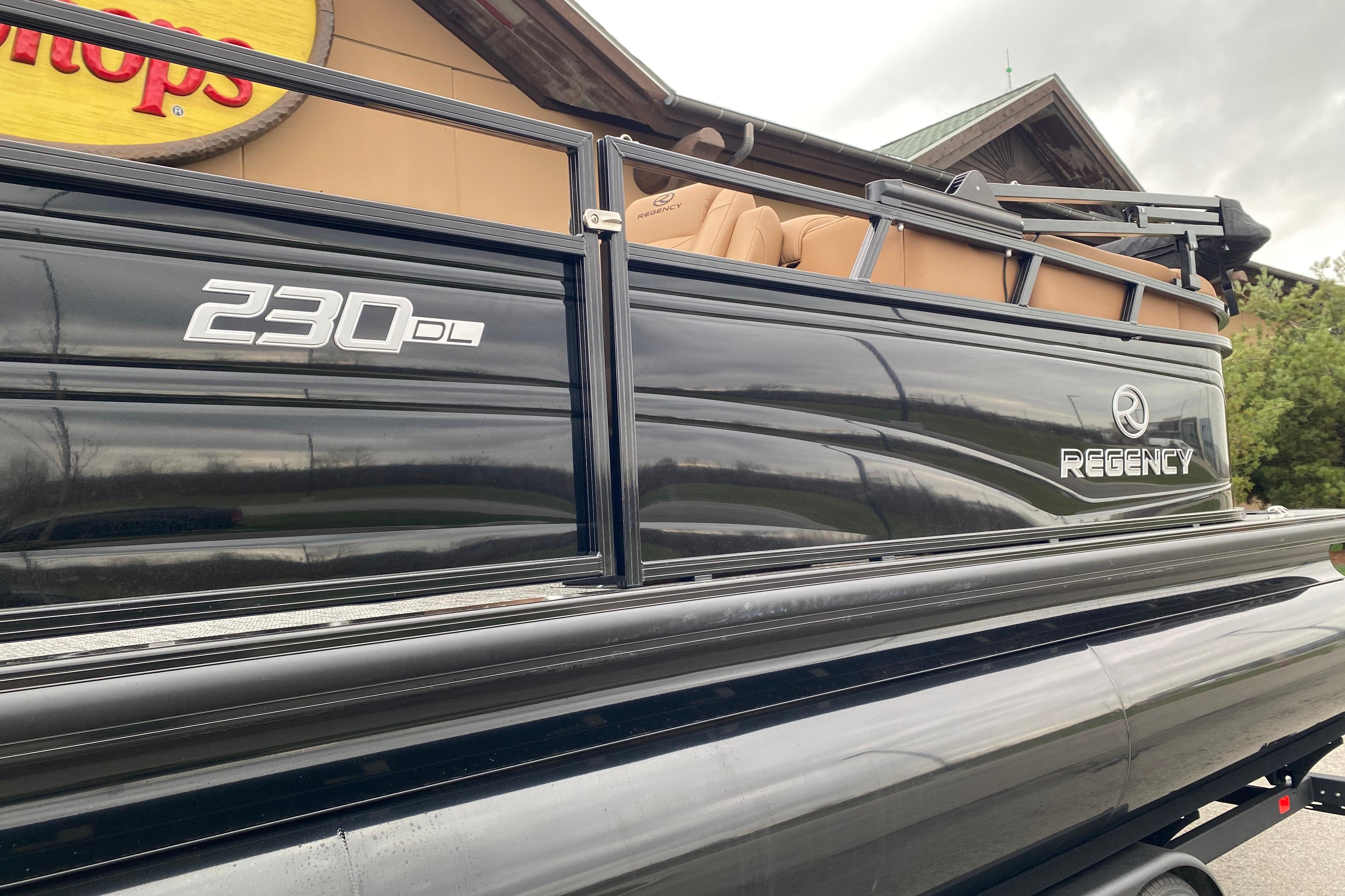 2026 Regency 230 DL pontoon boat with sleek black exterior and tan seating.