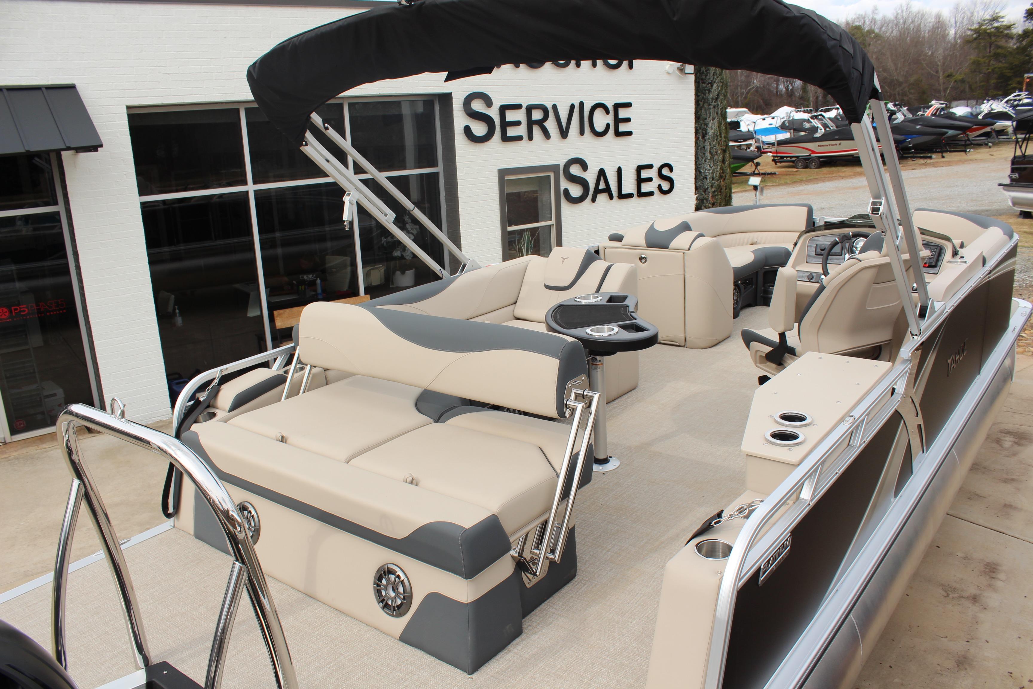 2026 Tahoe Pontoon LTZ boat with beige seating at a sales service location.
