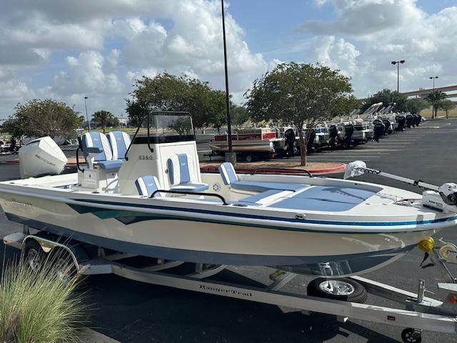 2025 Ranger 2360 Bay boat on trailer in parking lot, under cloudy sky.