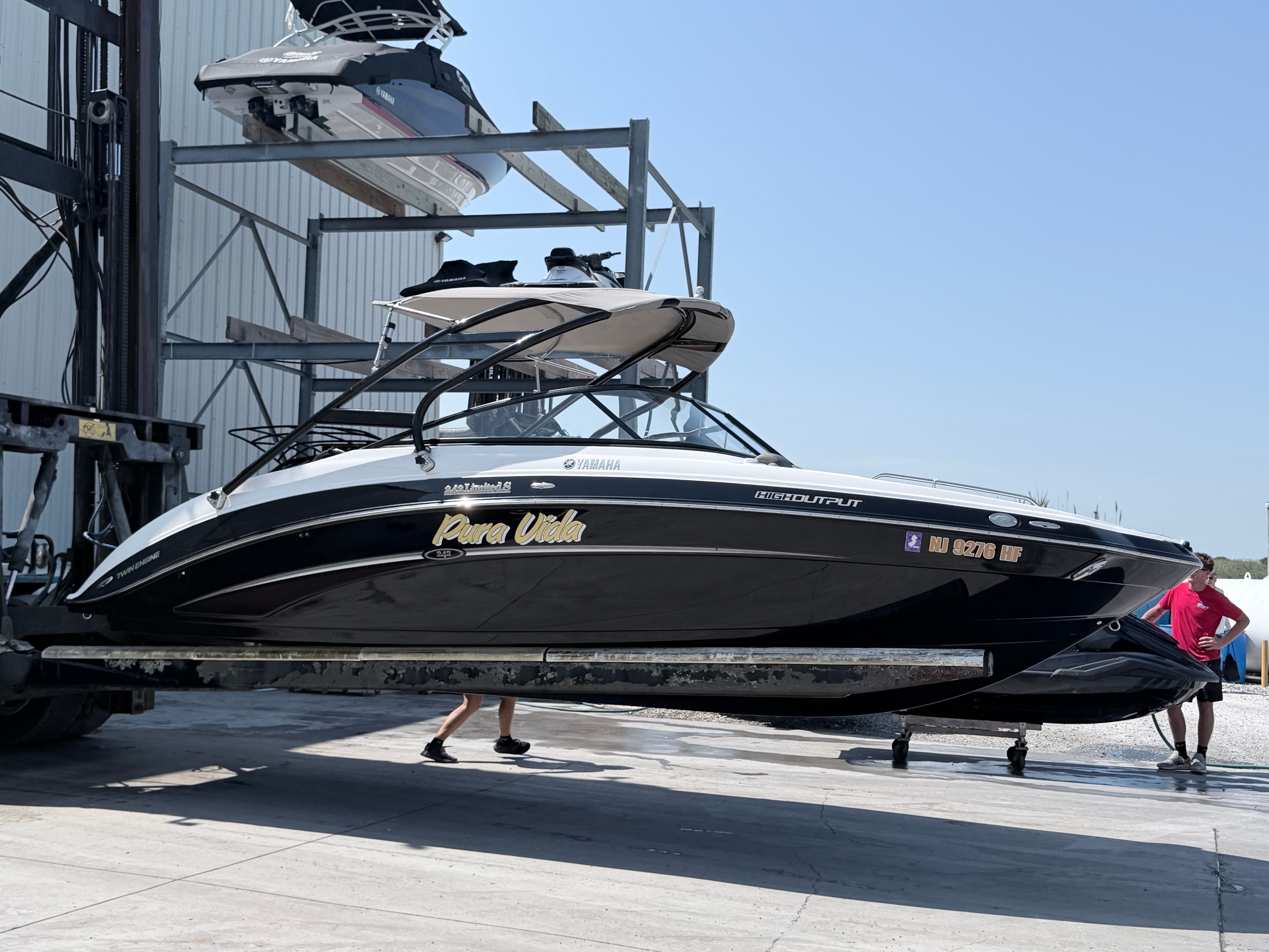 A 2014 Yamaha 242 Limited S boat being moved by a forklift.