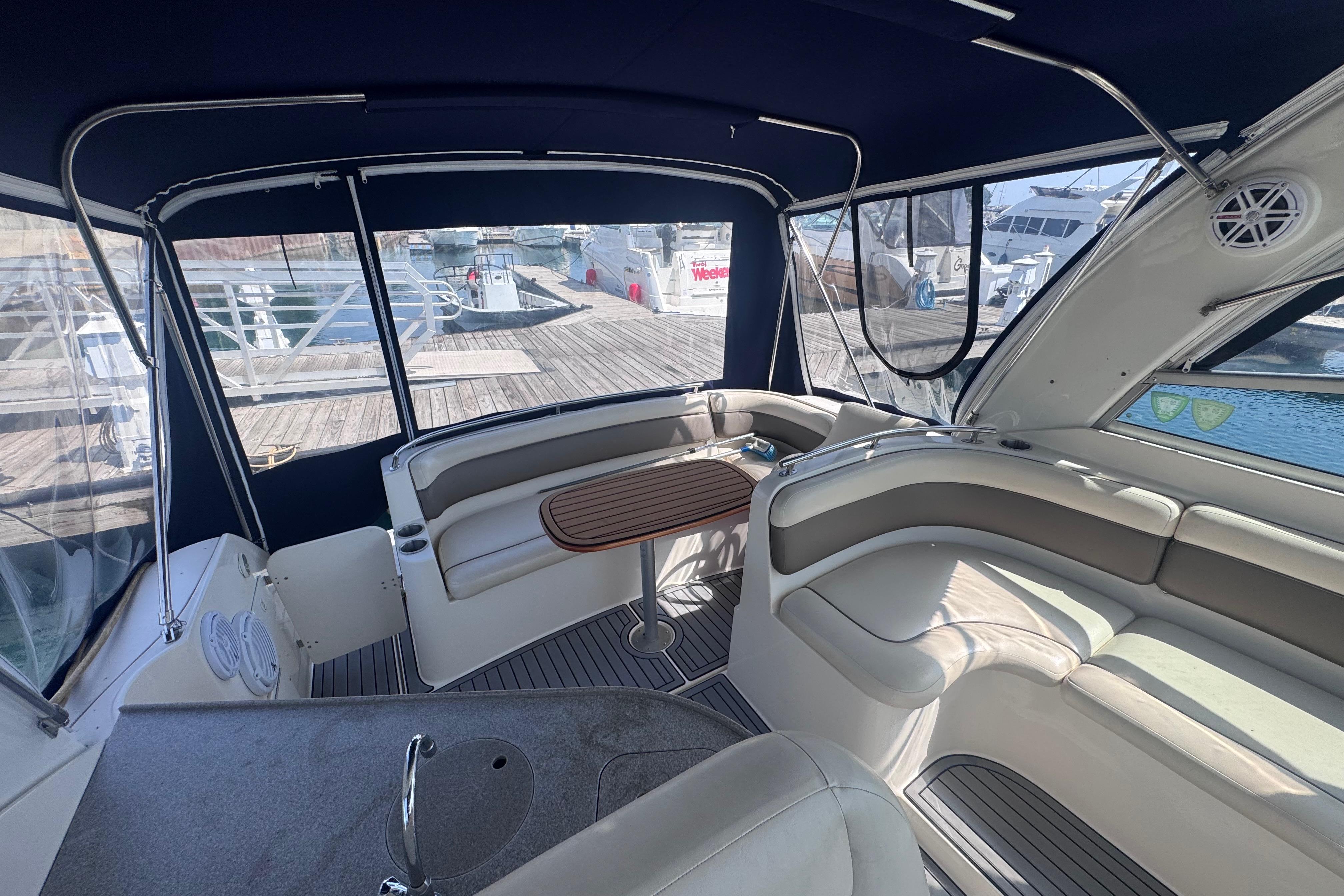 2003 Rinker Fiesta Vee 312 boat interior with seating and table, docked at marina.