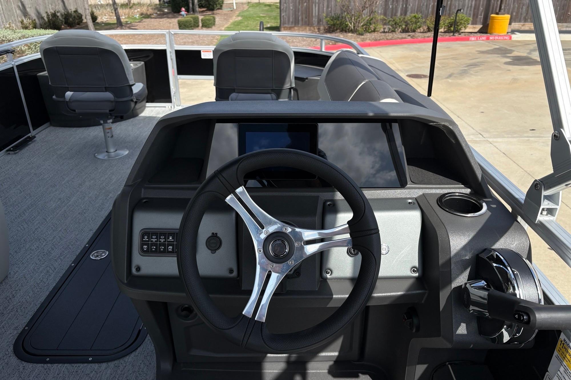 2026 Sun Tracker Fishin' Barge 22 XP3 dashboard with steering wheel and controls.