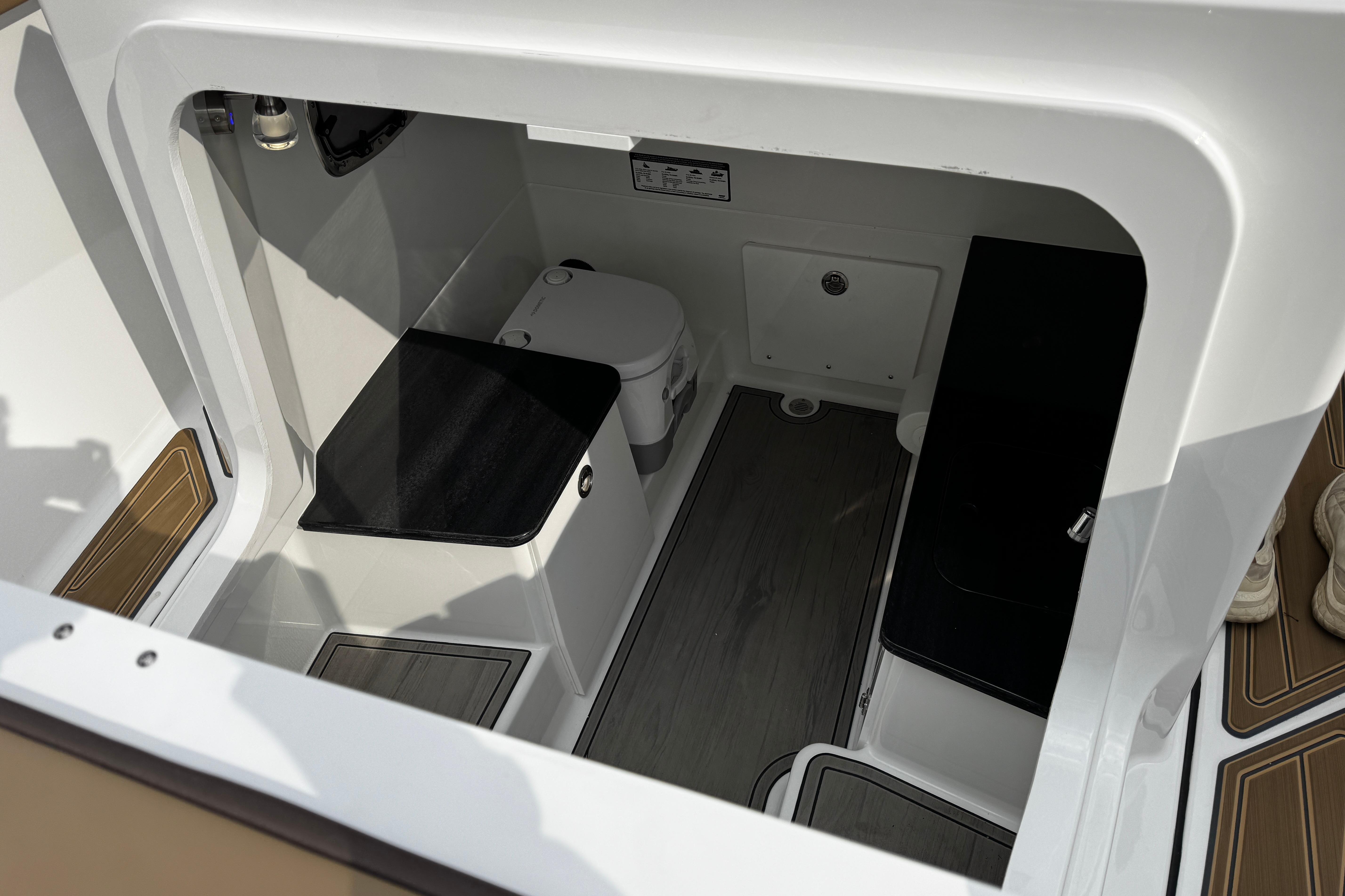 Interior view of 2026 Monterey Elite 25 OB boat cabin with seating and storage.