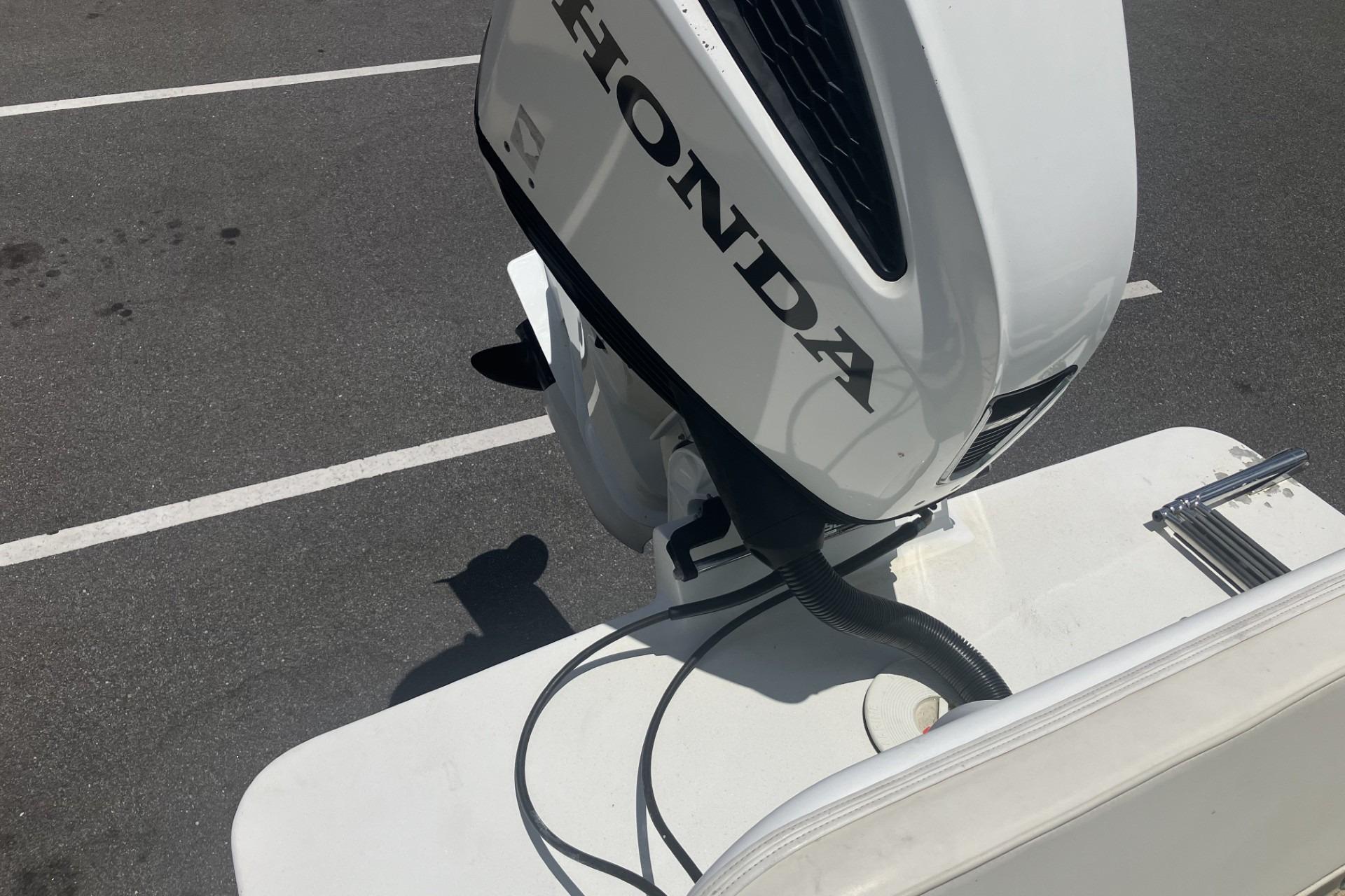 2022 May-Craft 2300 CCX boat with Honda outboard motor in parking lot.