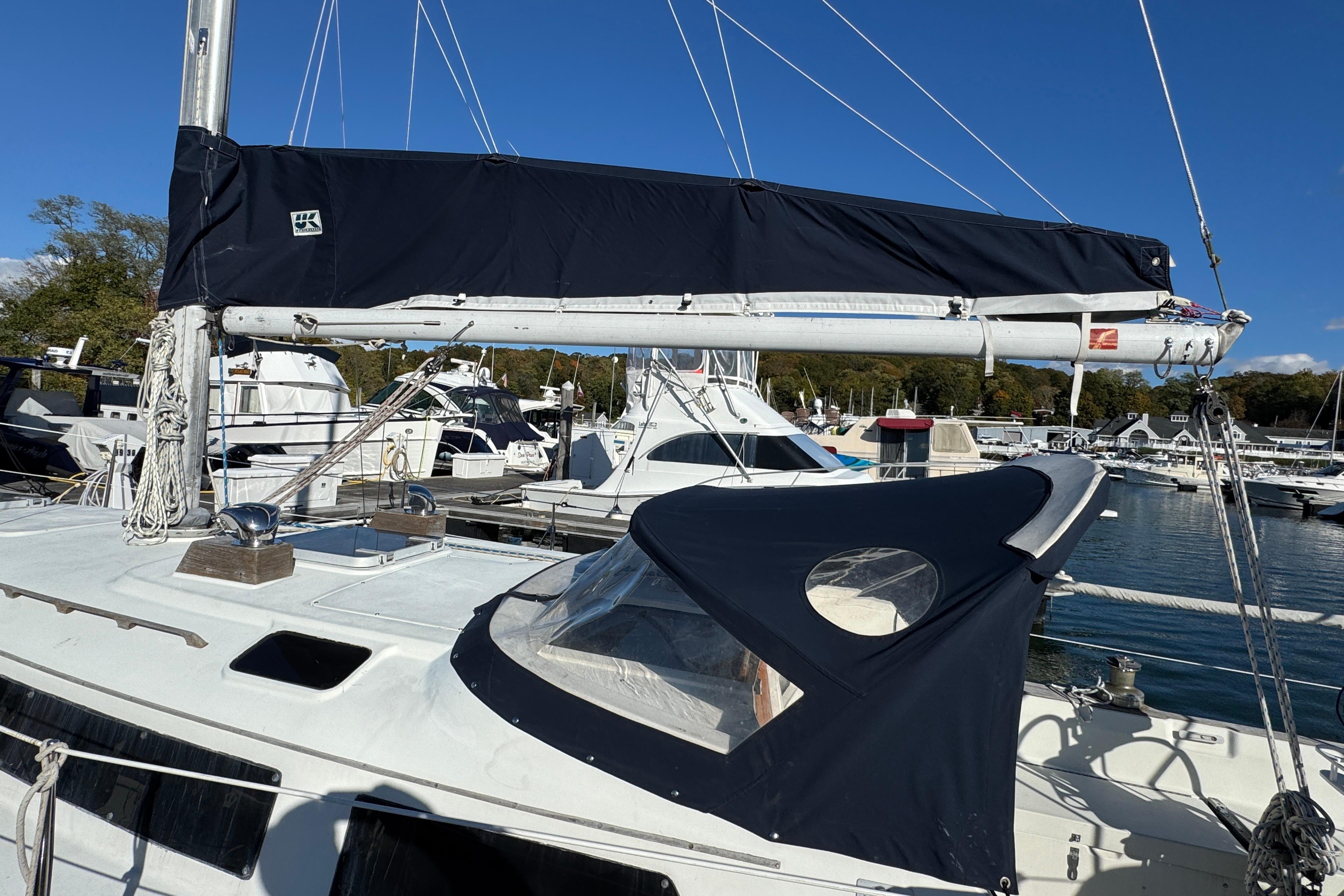 1984 C&C Landfall sailboat docked at marina under clear blue sky.