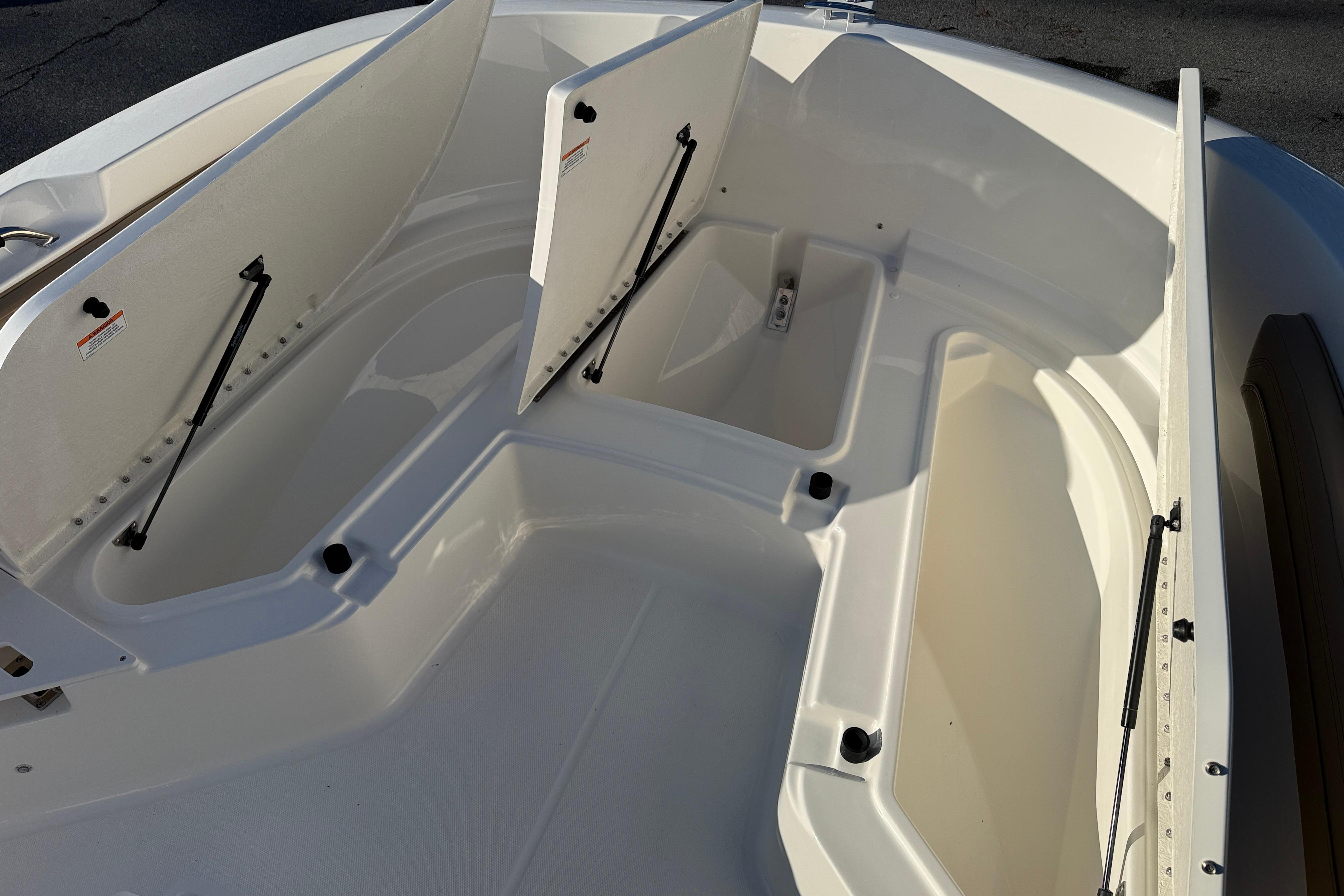 2026 Bayliner Trophy T22CC boat storage compartments open, showcasing spacious interior design.