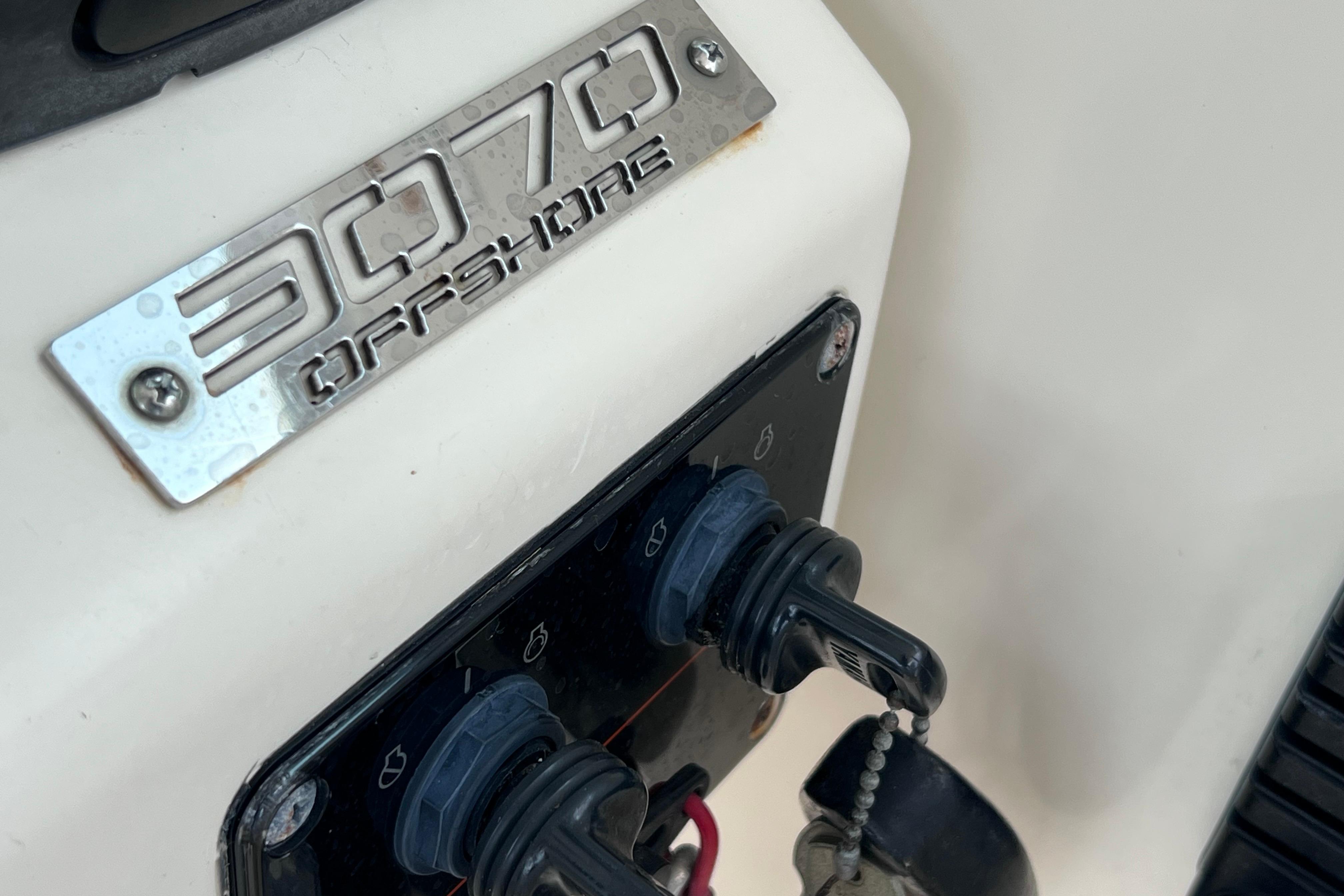 Close-up of 2005 Pursuit 3070 Offshore boat control panel with logo.