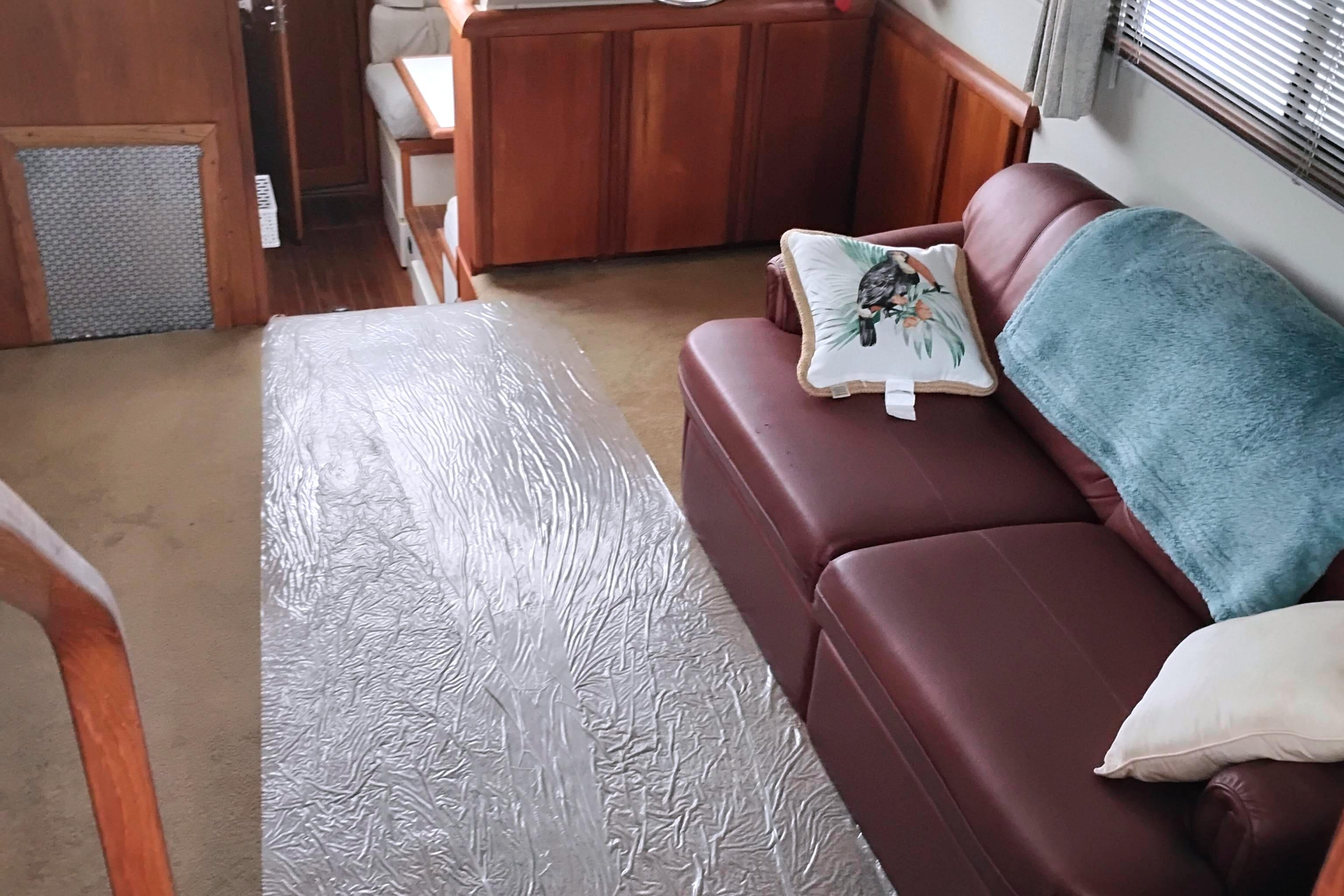 Interior of 1991 Californian 52 Cockpit Motor Yacht with leather sofa and decorative pillows.