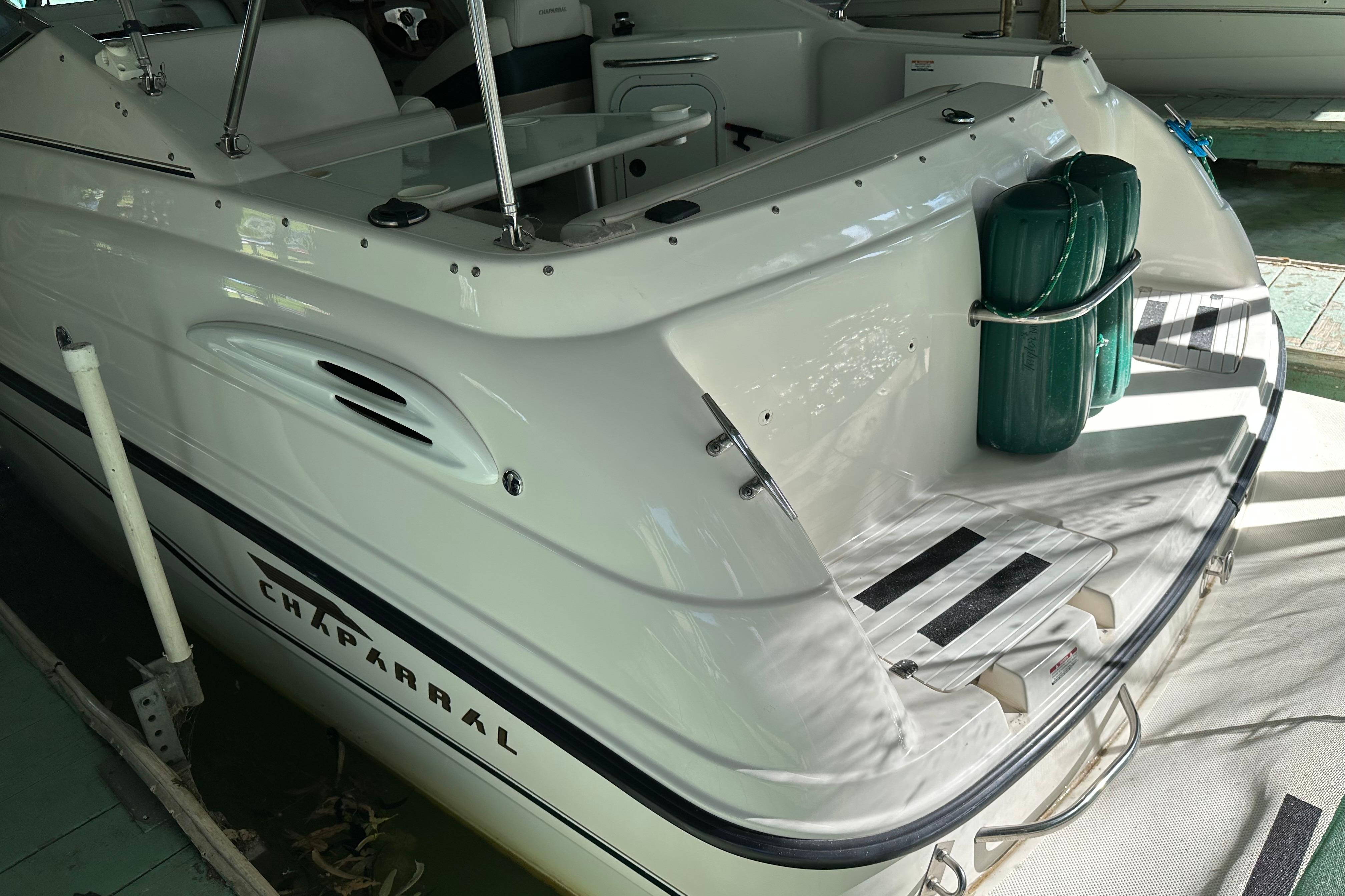 1998 Chaparral Signature 2600 boat, rear view, docked with green fenders.