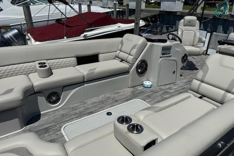Luxurious interior of 2021 Crest Caribbean LX 250 SLS pontoon boat with plush seating and cup holders.