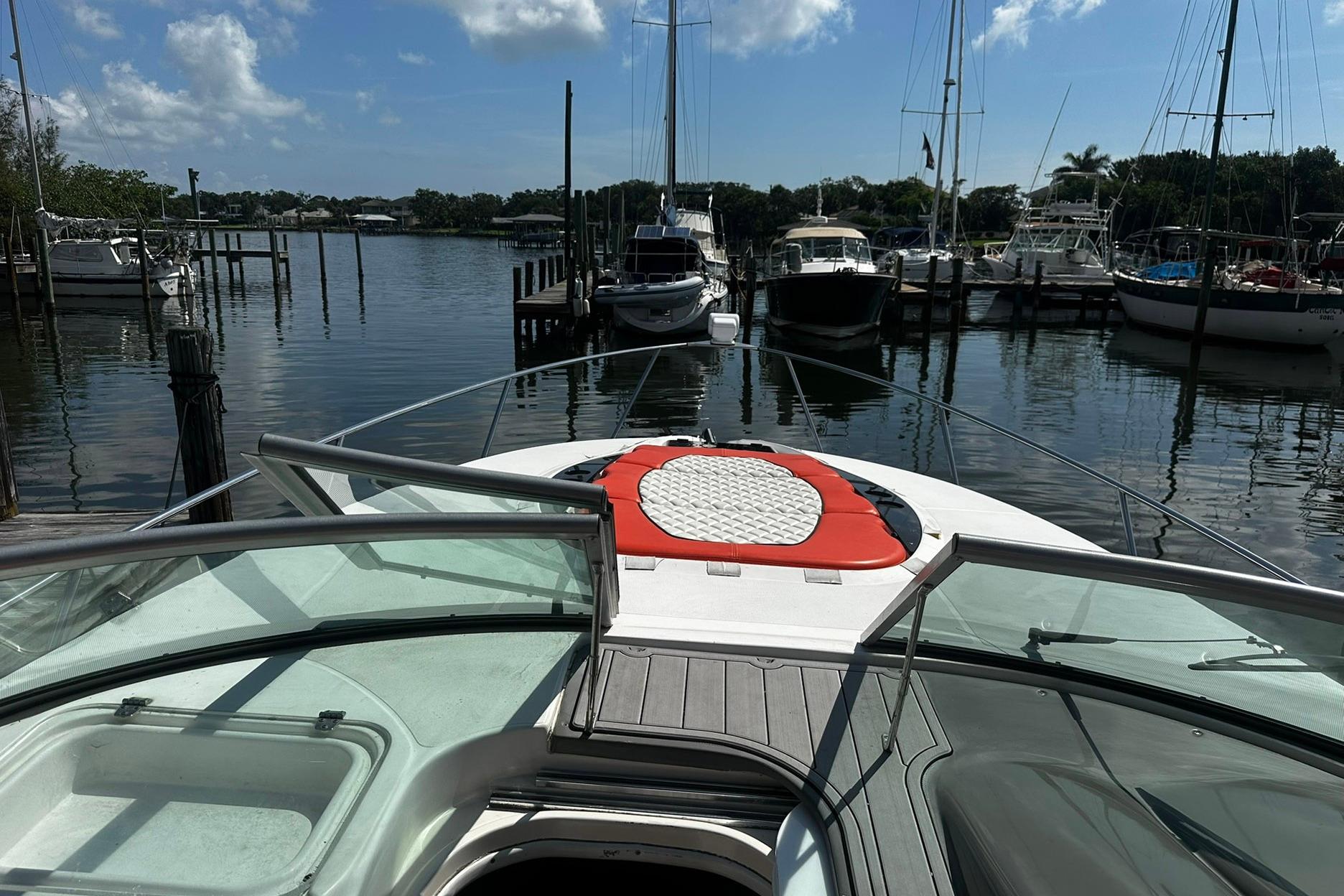 2012 Rinker 310 Express Cruiser LE docked in a serene marina setting.
