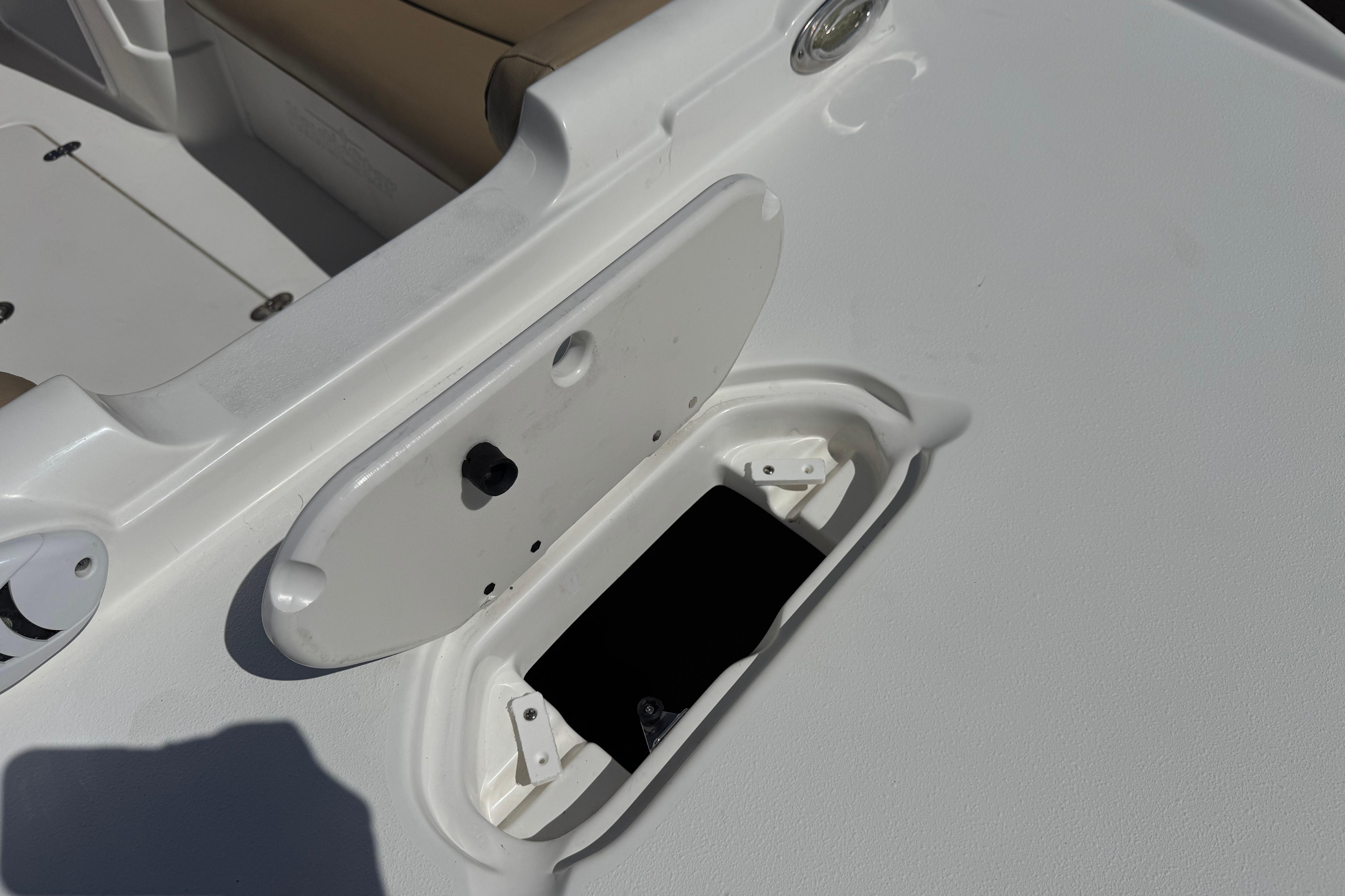 2020 NauticStar 203 SC boat storage compartment with open hatch and beige seating.