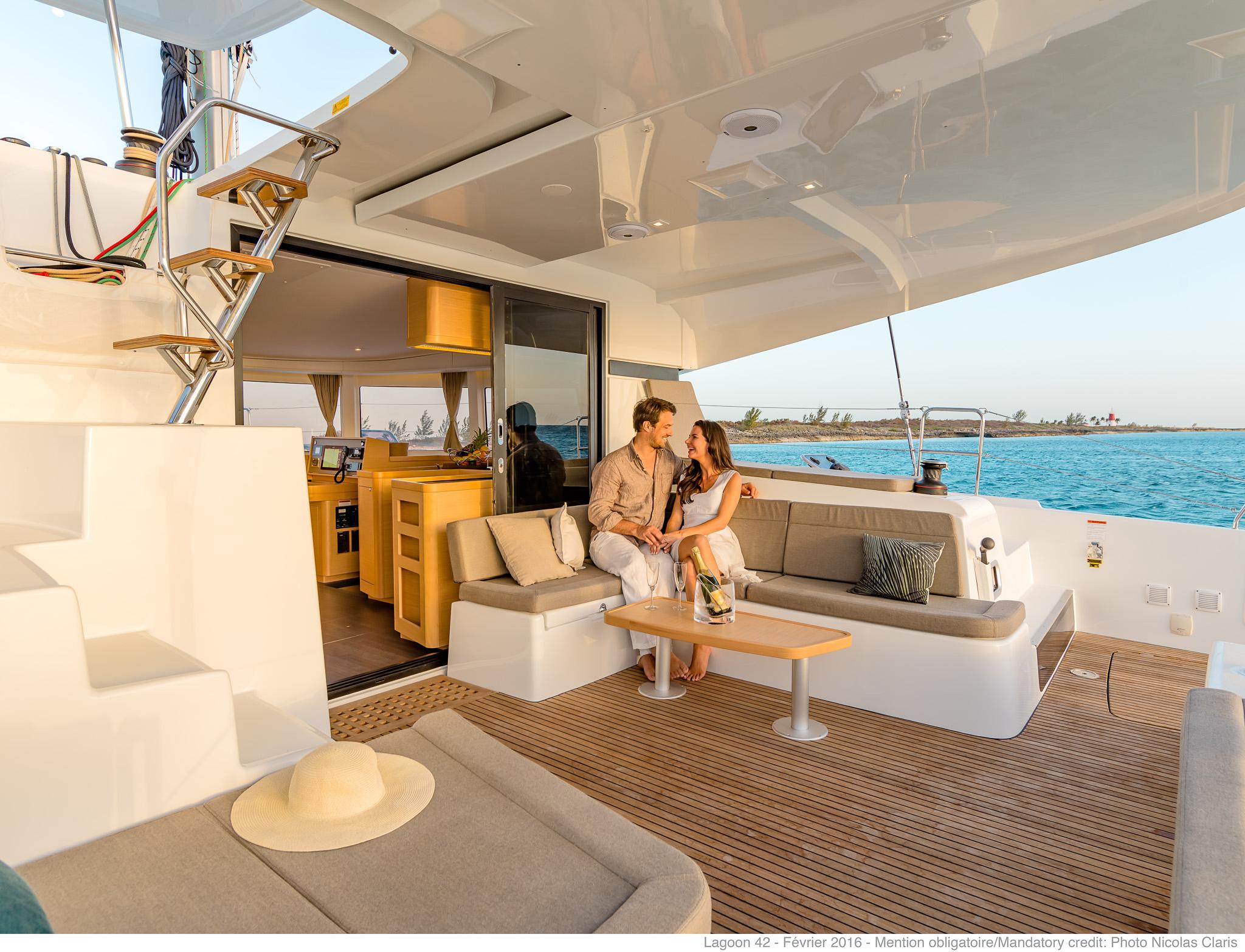 Couple relaxing on Lagoon 42 Millenium yacht, 2025 model, with ocean view.