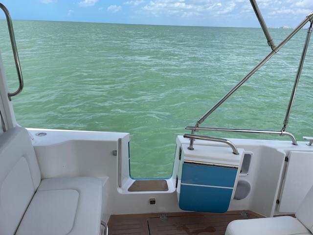 2023 MJM 35z boat interior with ocean view, featuring white seating and blue accents.