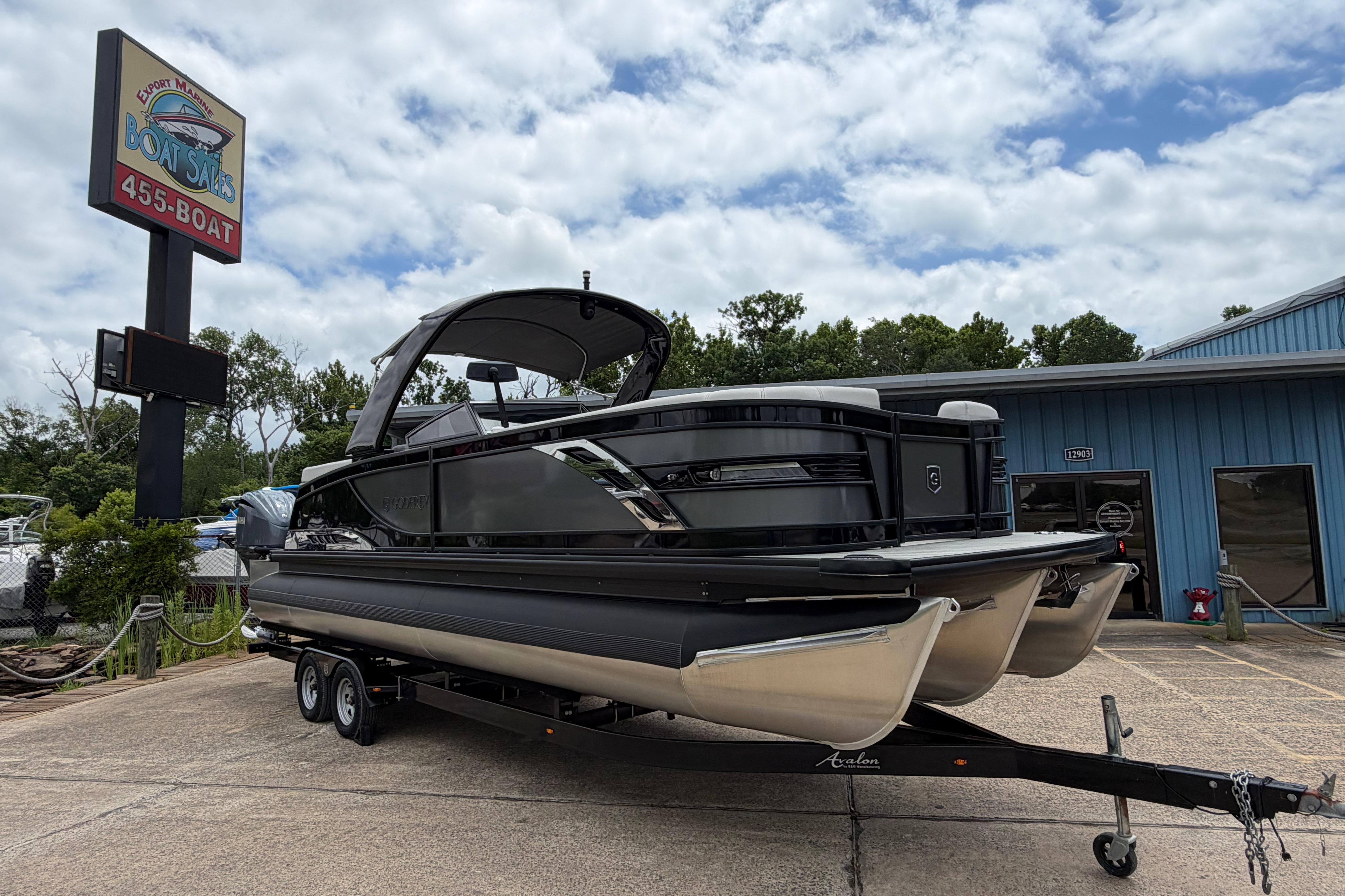 2023 Godfrey Sanpan 2700 ULW Twin pontoon boat on trailer at dealership.