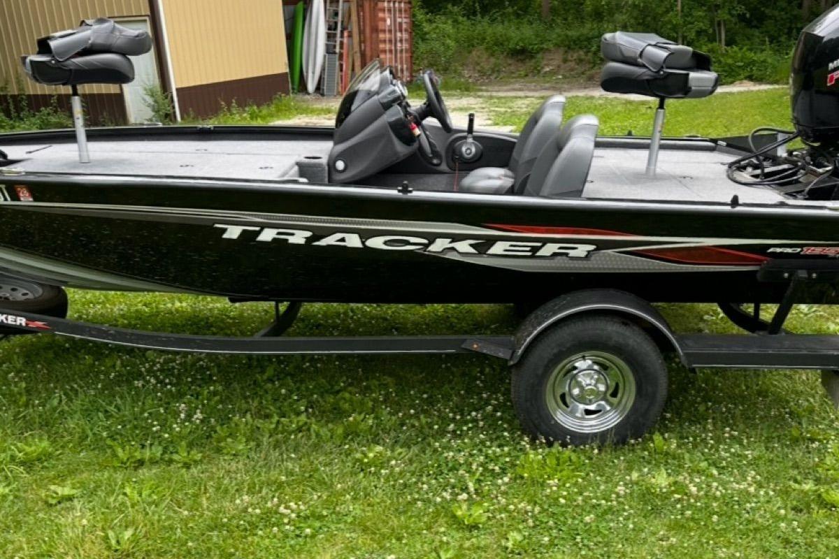 2022 Bass Tracker 195TXW fishing boat on trailer, parked on grass.