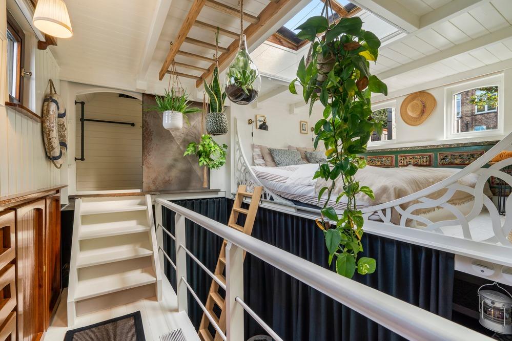 Interior of a 1930 Woonschip houseboat with plants and cozy decor.