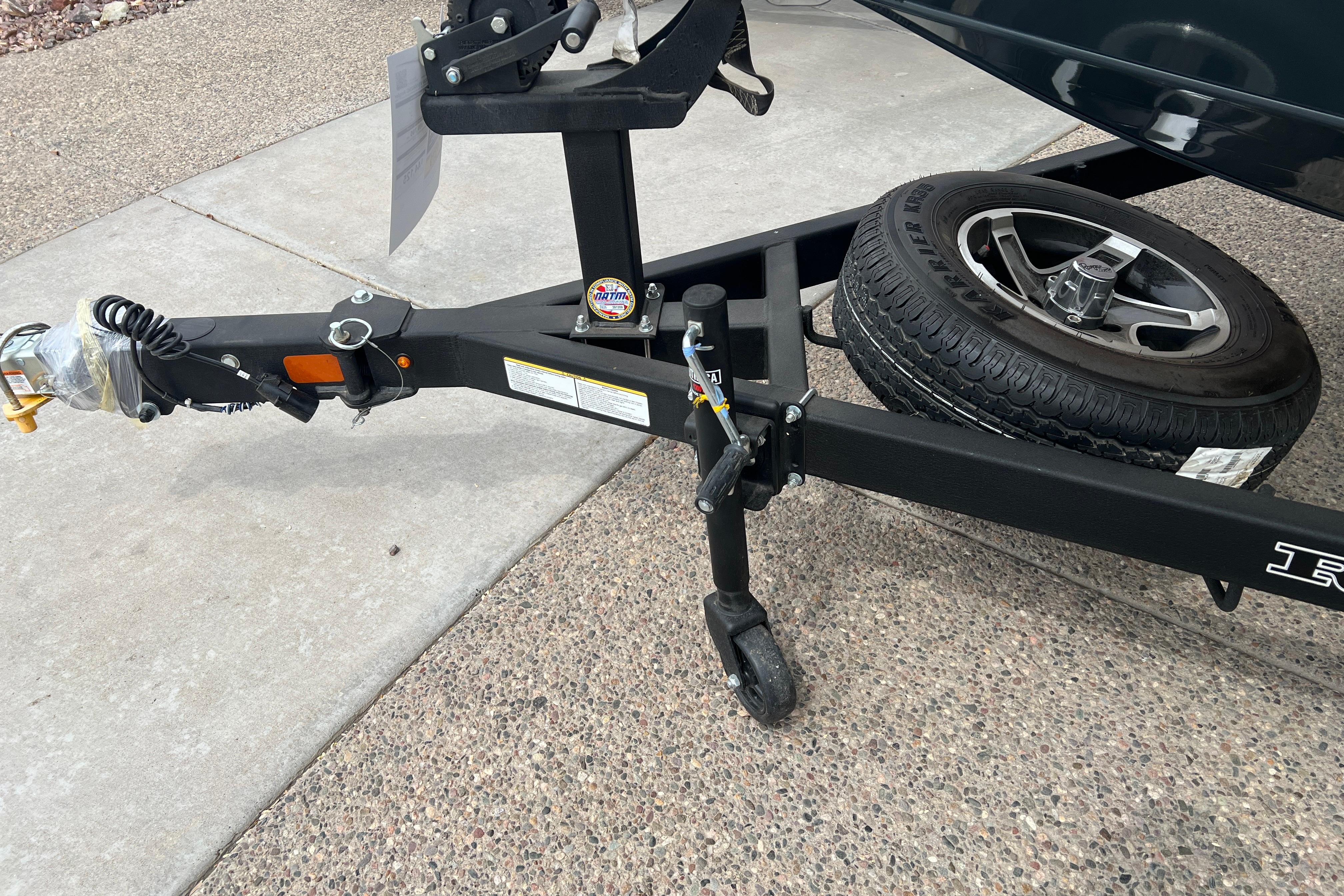 Trailer hitch and spare tire of 2026 Ranger VS1682SC Angler boat on pavement.