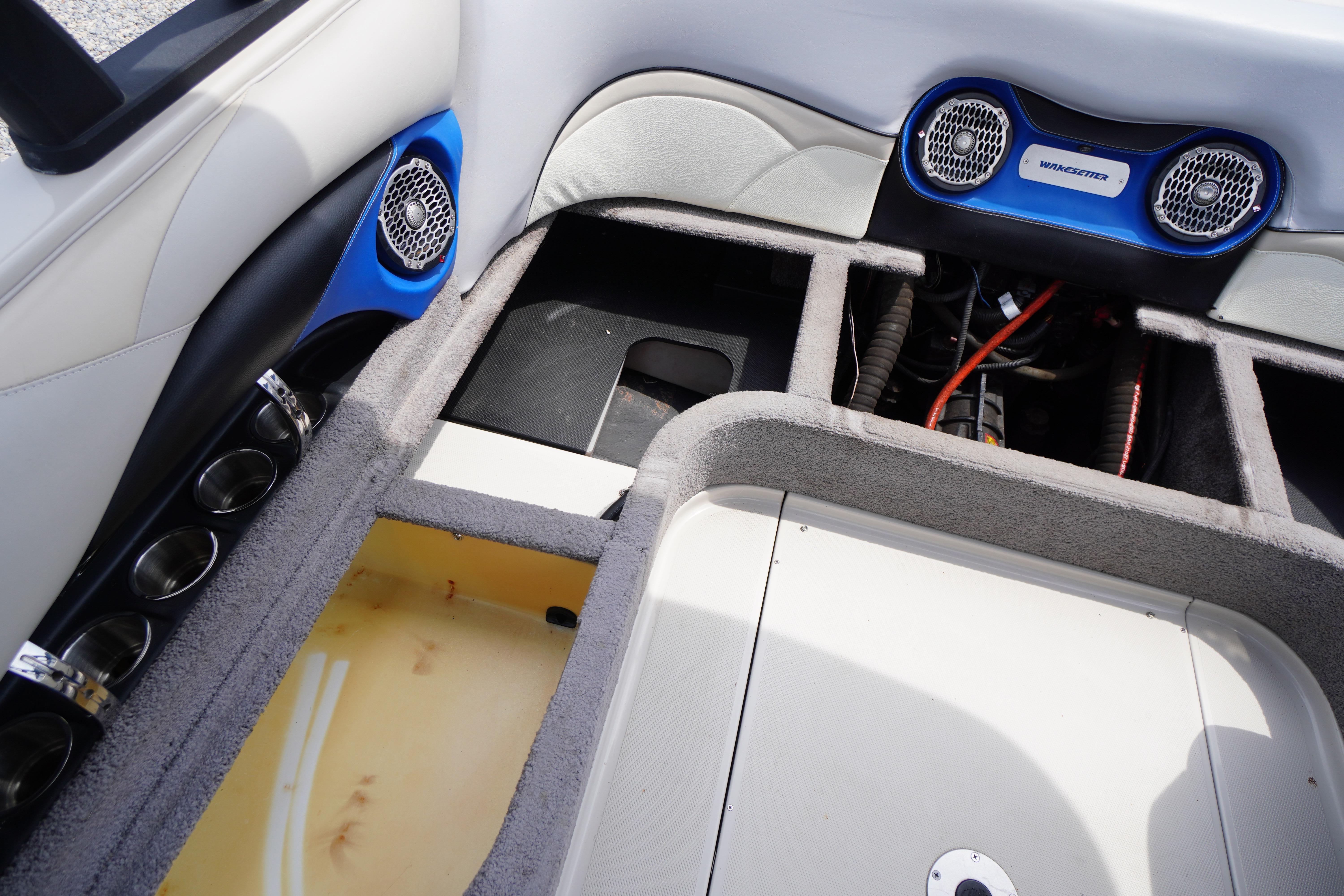 Interior view of a 2011 Malibu Wakesetter 21 VLX boat, showcasing storage compartments and speakers.