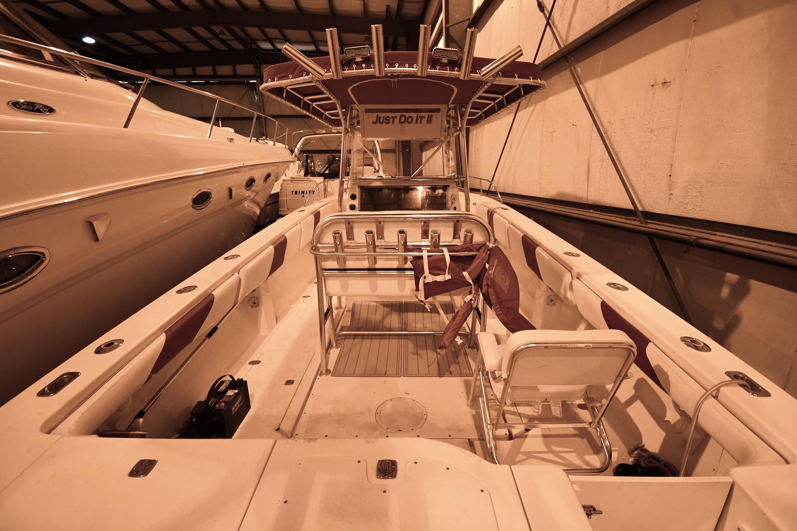 2001 Fountain 38 Center Console boat in indoor storage, featuring spacious seating and fishing rod holders.