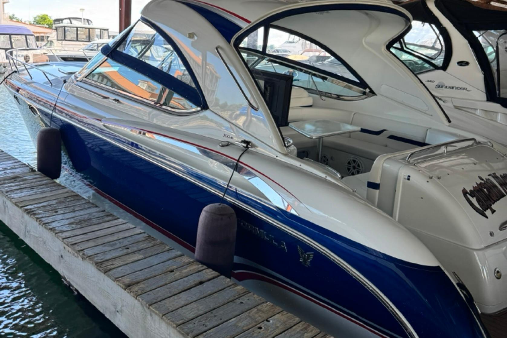 2008 Formula 400 Super Sport boat docked at marina, featuring sleek blue and white design.