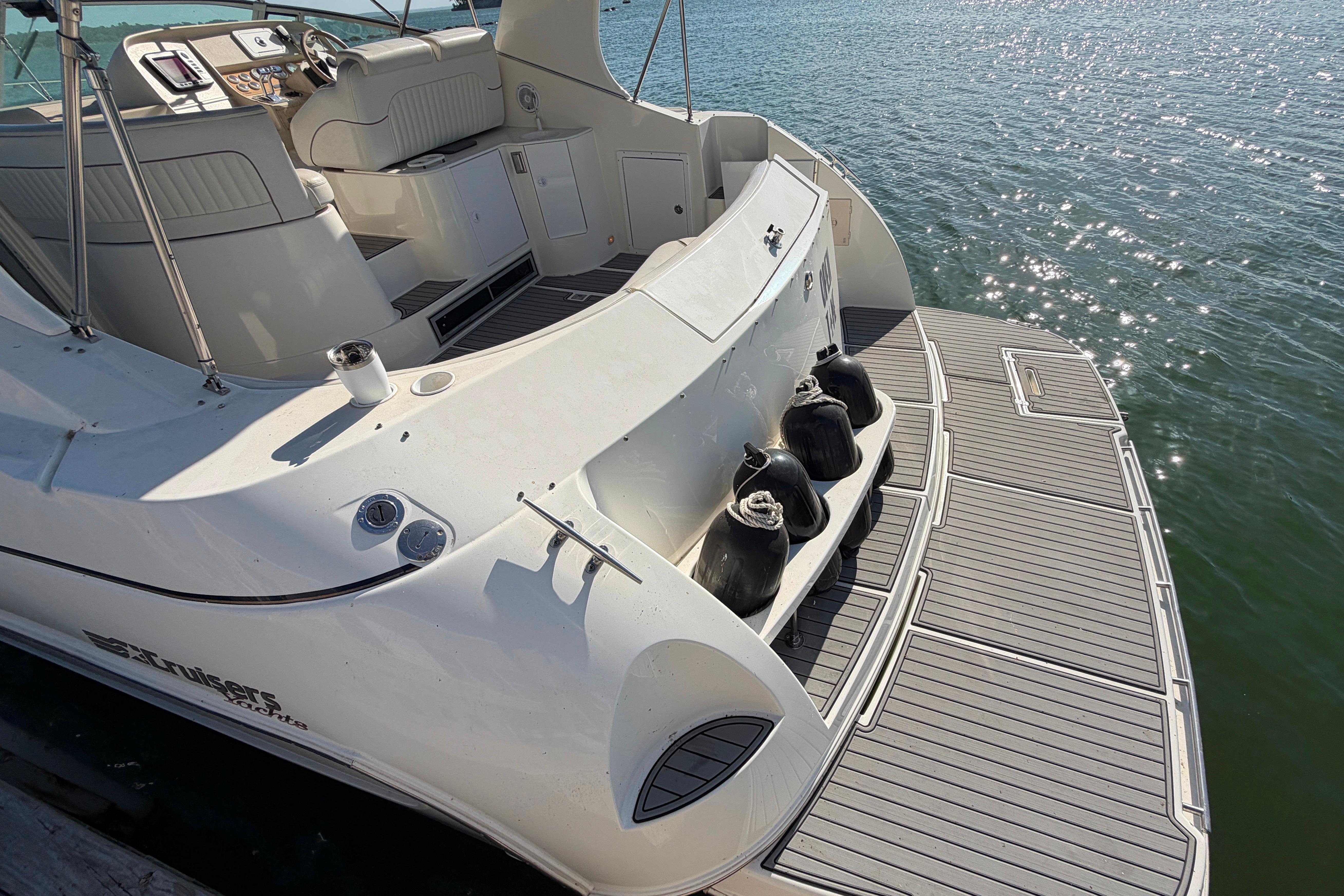 1997 Cruisers 3575 yacht with spacious deck, docked on calm water.
