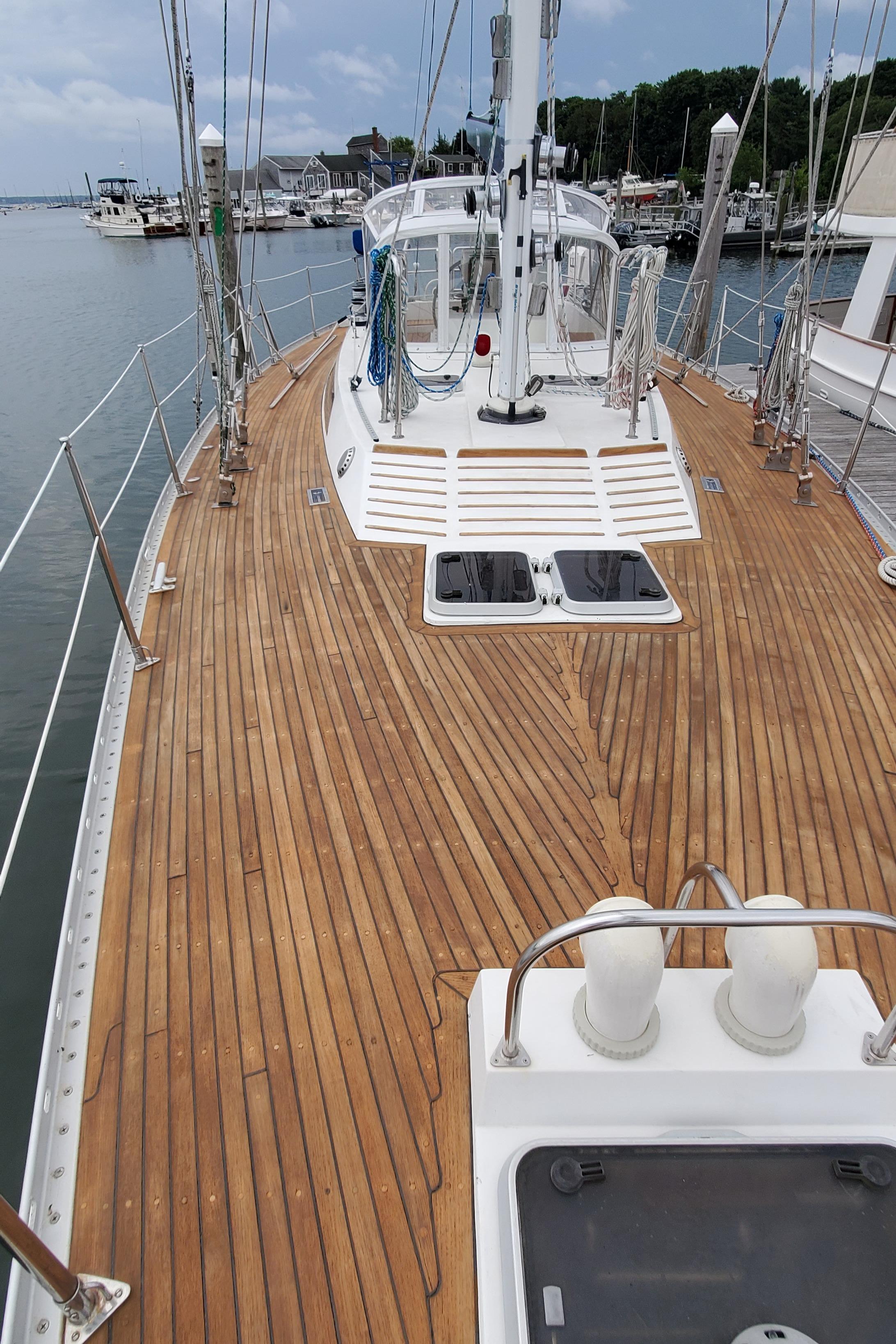 1989 Tayana 55 sailboat with teak deck, docked at marina, showcasing elegant design and craftsmanship.