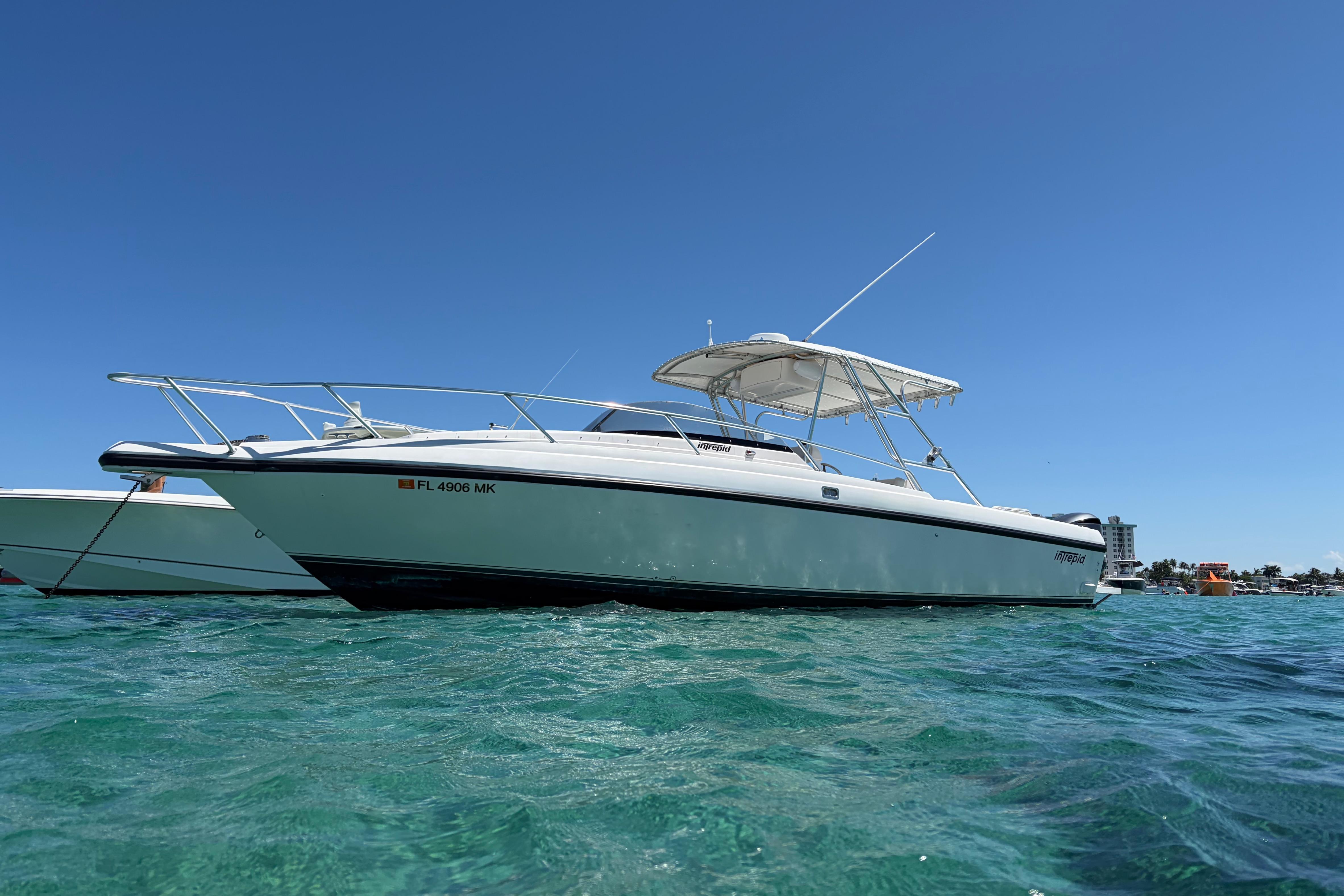 1998 Intrepid 339 Walkaround boat on clear blue water under a sunny sky.