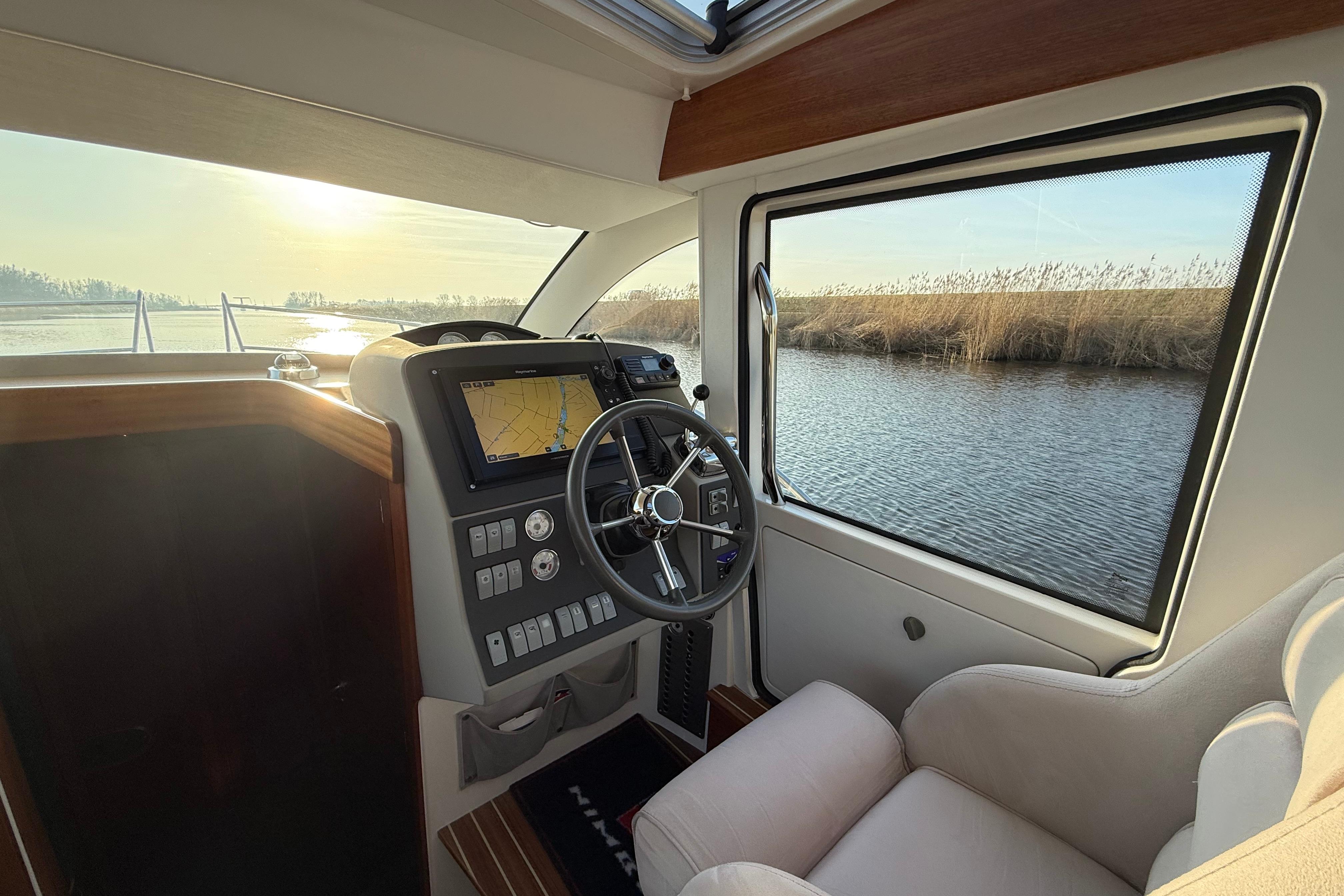 Interior of 2011 Nimbus 335 Coupe boat with steering wheel and navigation system.