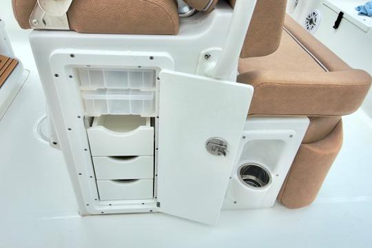 2026 Sea Hunt Ultra 255 SE boat interior storage compartment with open door and drawers.