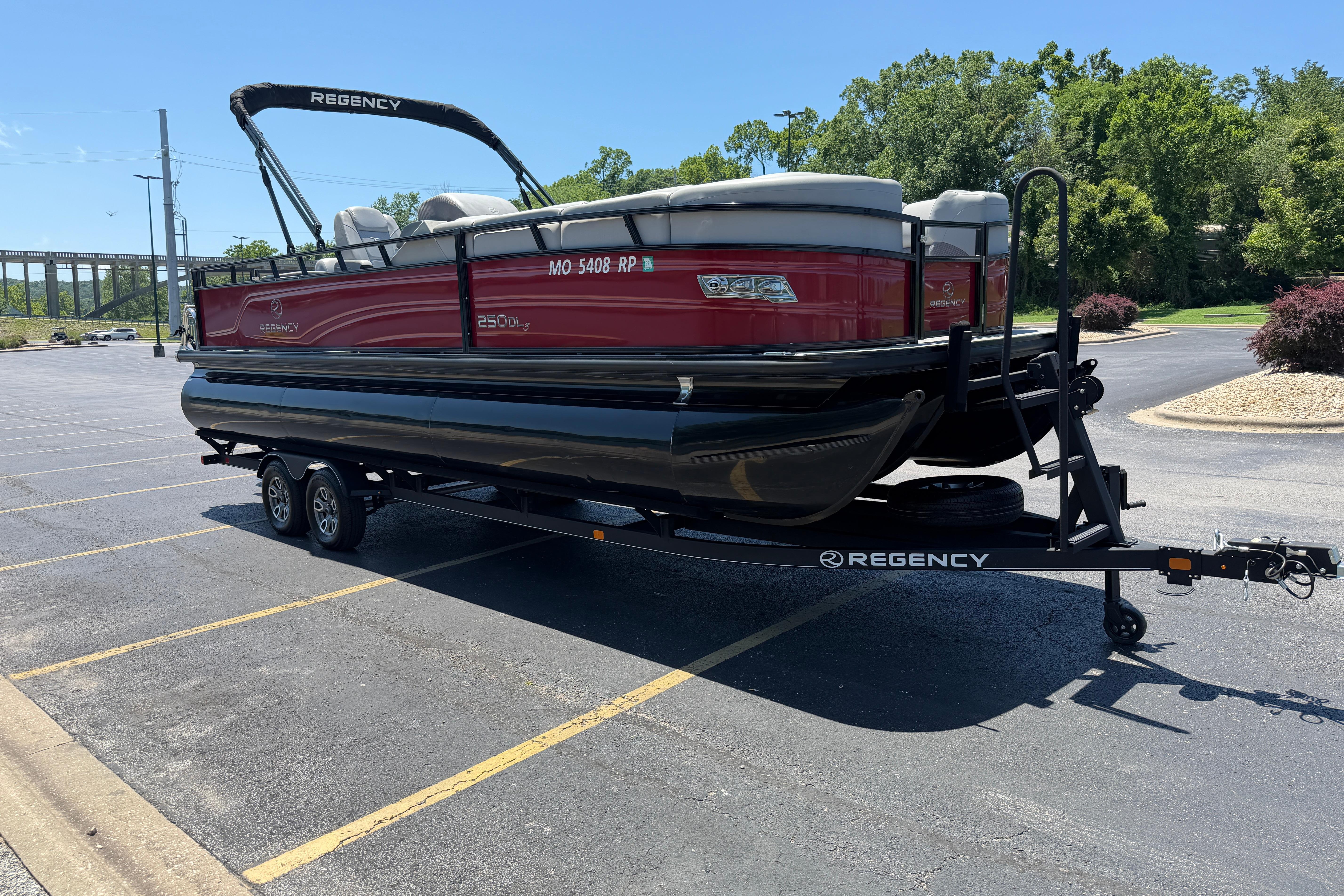 2024 Regency R250DL3 pontoon boat on trailer in parking lot, sunny day.