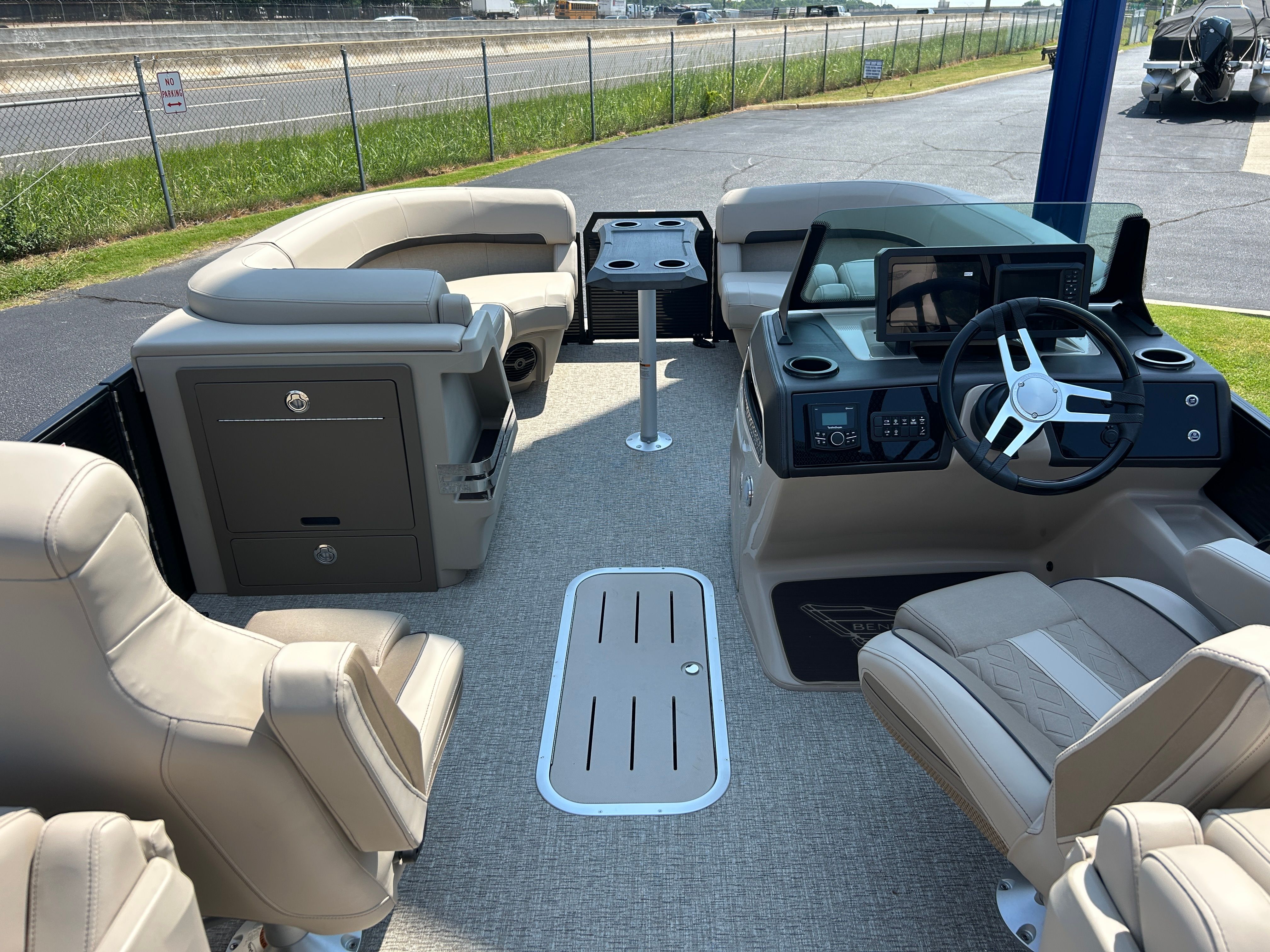 Interior of a 2026 Bennington 22 MFB with beige seating and a modern helm station.