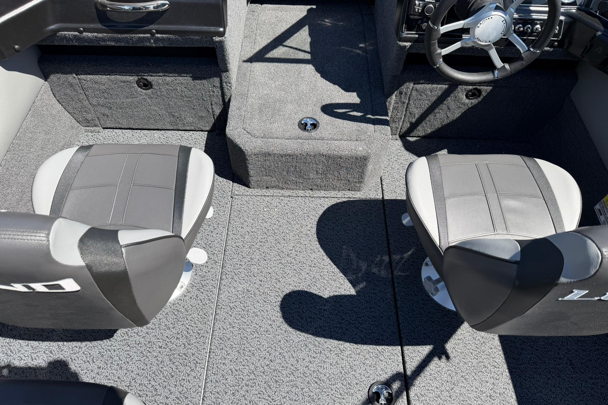 Interior of 2027 Lund 1775 Crossover XS boat with gray seating and steering wheel.