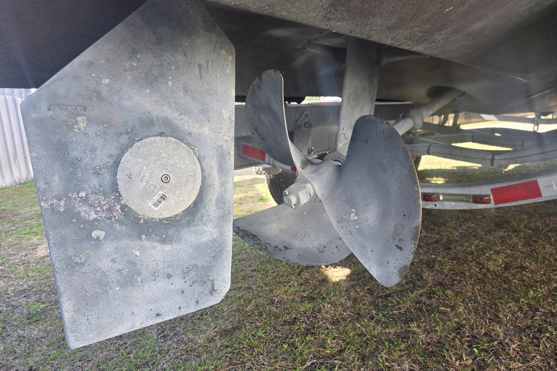 Propeller and rudder of a 2008 True World Marine TE2810 boat on a trailer.