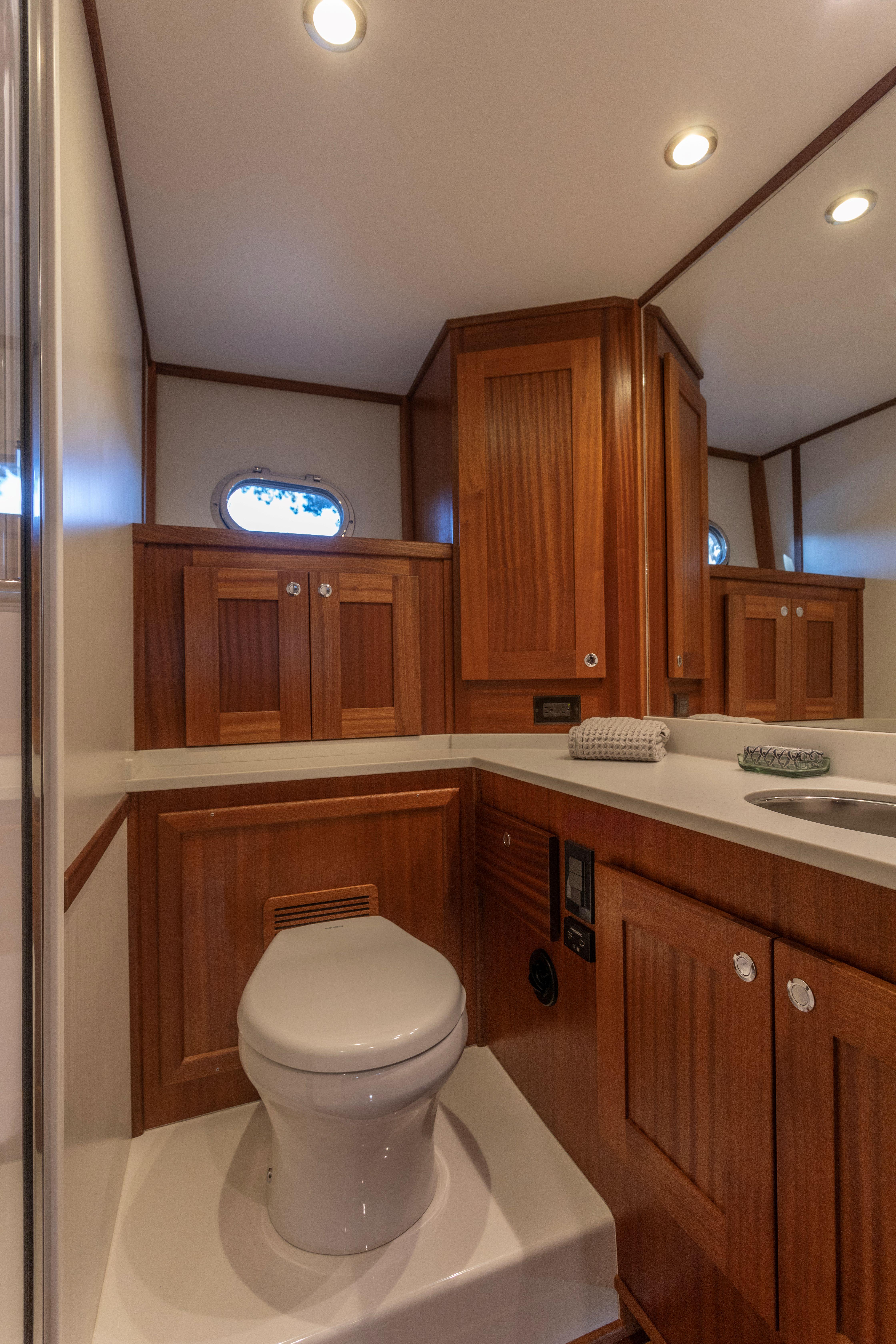 Luxurious bathroom in 2026 American Tug 435 yacht with wooden cabinetry and modern fixtures.