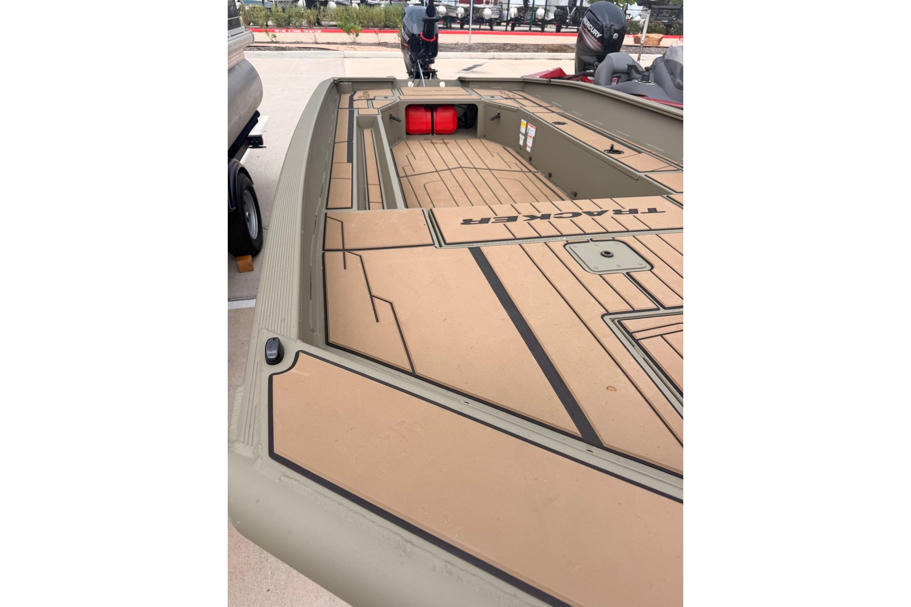 2026 Tracker Grizzly 1756 MARSH boat with tan deck and storage compartments.