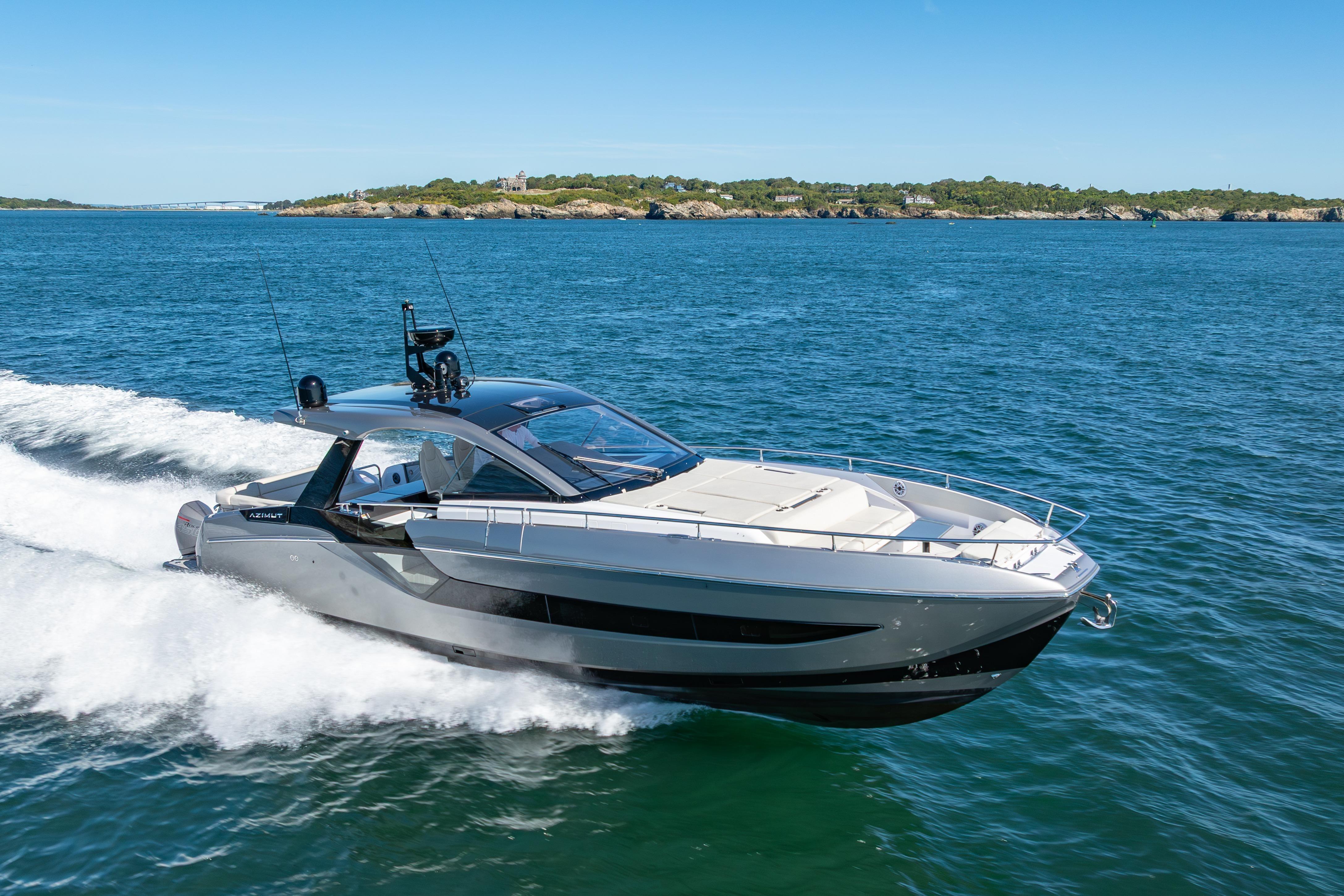 The 2023 Azimut Verve 47 speeds across blue water, surrounded by a coastal landscape.