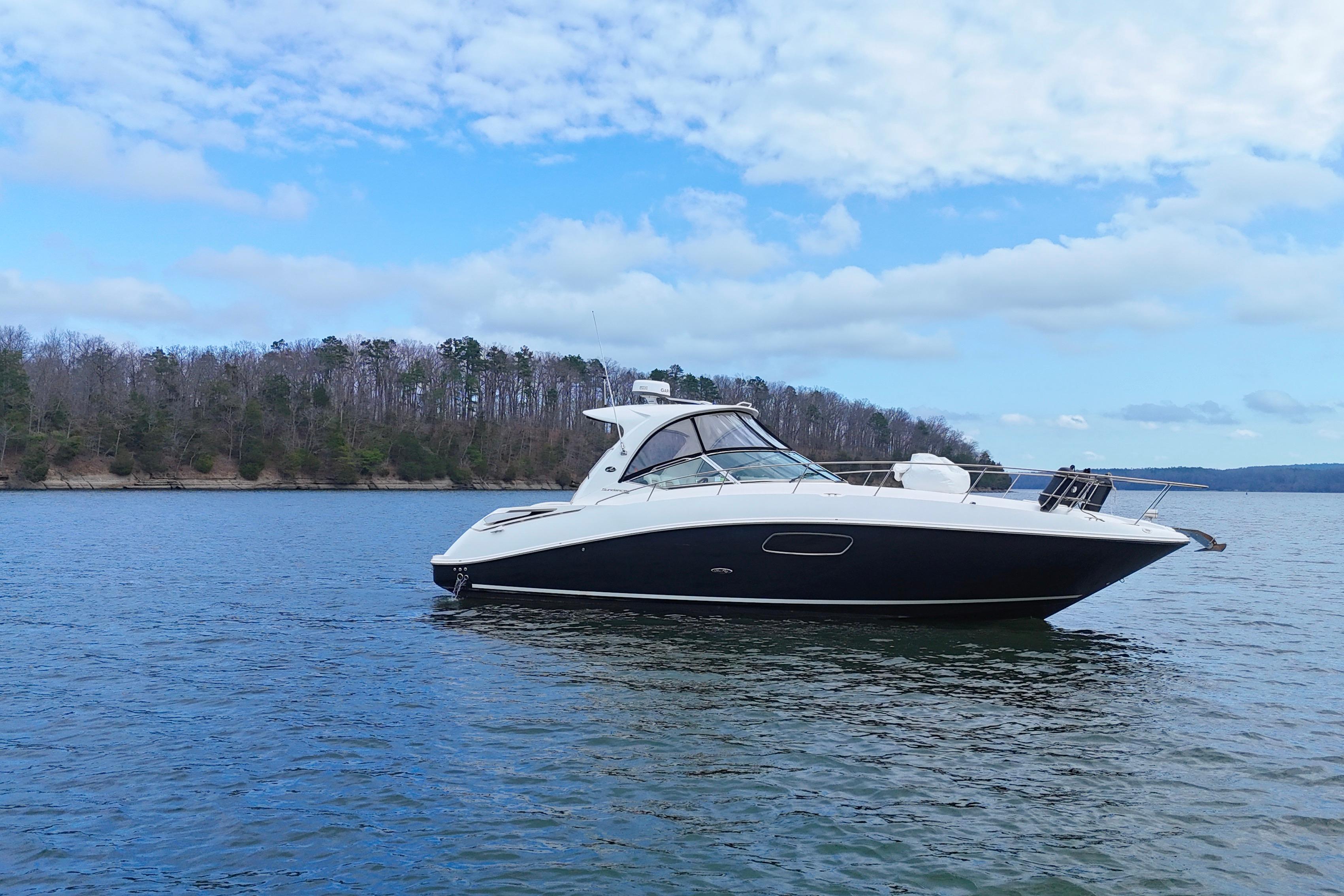 2009 Sea Ray Sundancer 350 yacht on a serene lake under a partly cloudy sky.