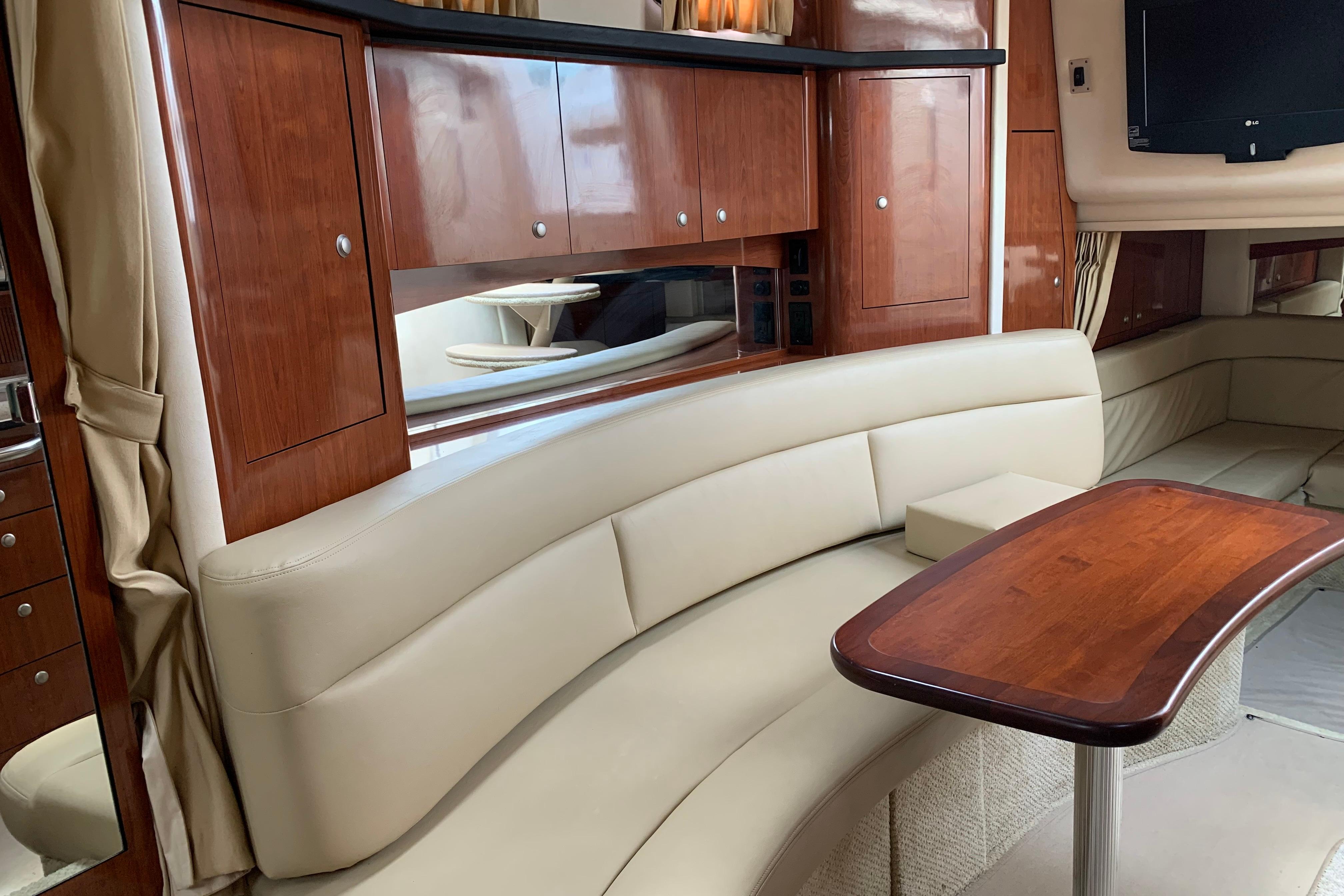 Luxurious interior of 2007 Sea Ray 340 Sundancer with leather seating and wooden cabinetry.