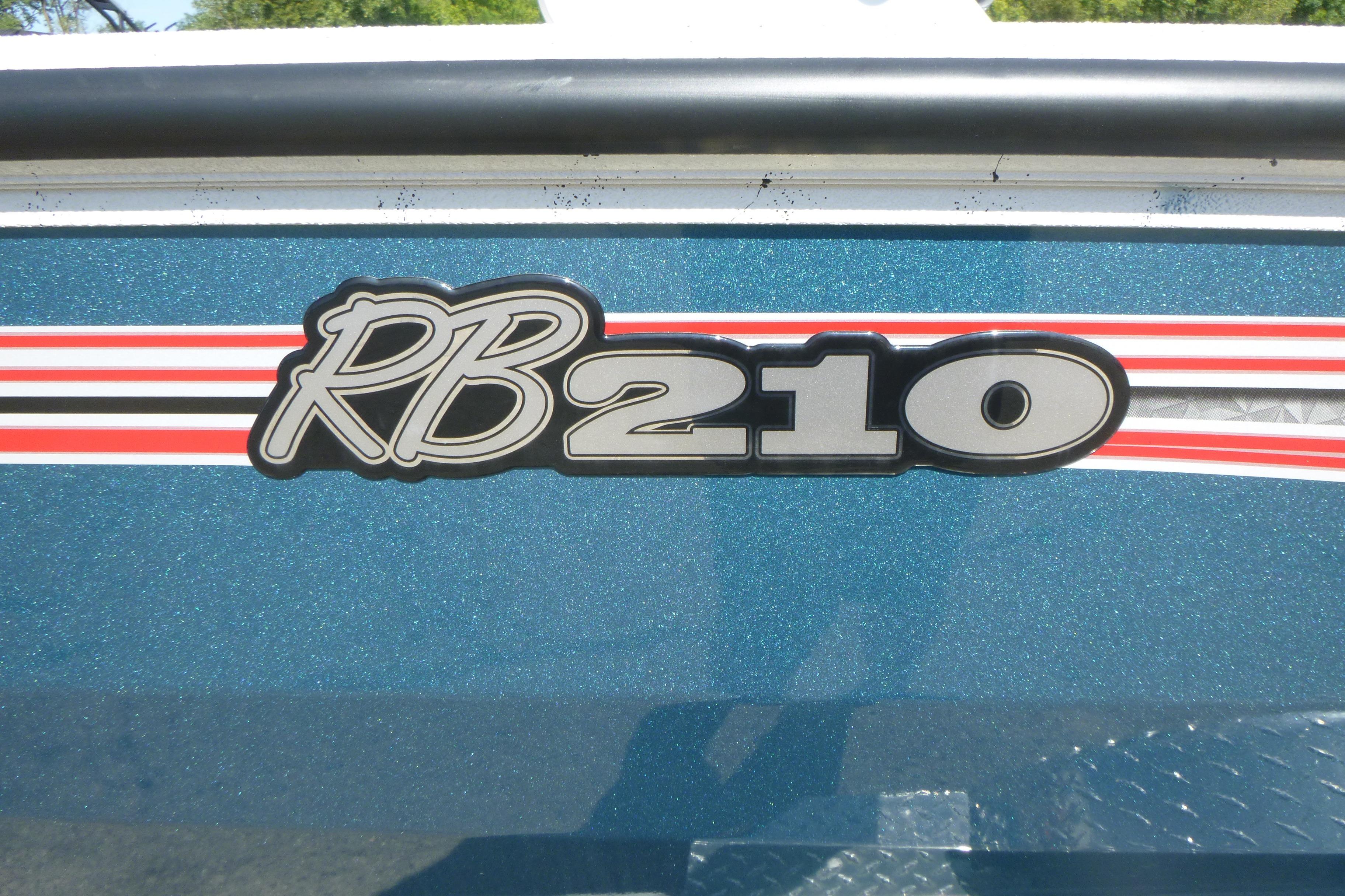 2025 Ranger RB210 logo on blue metallic surface with red and white stripes.