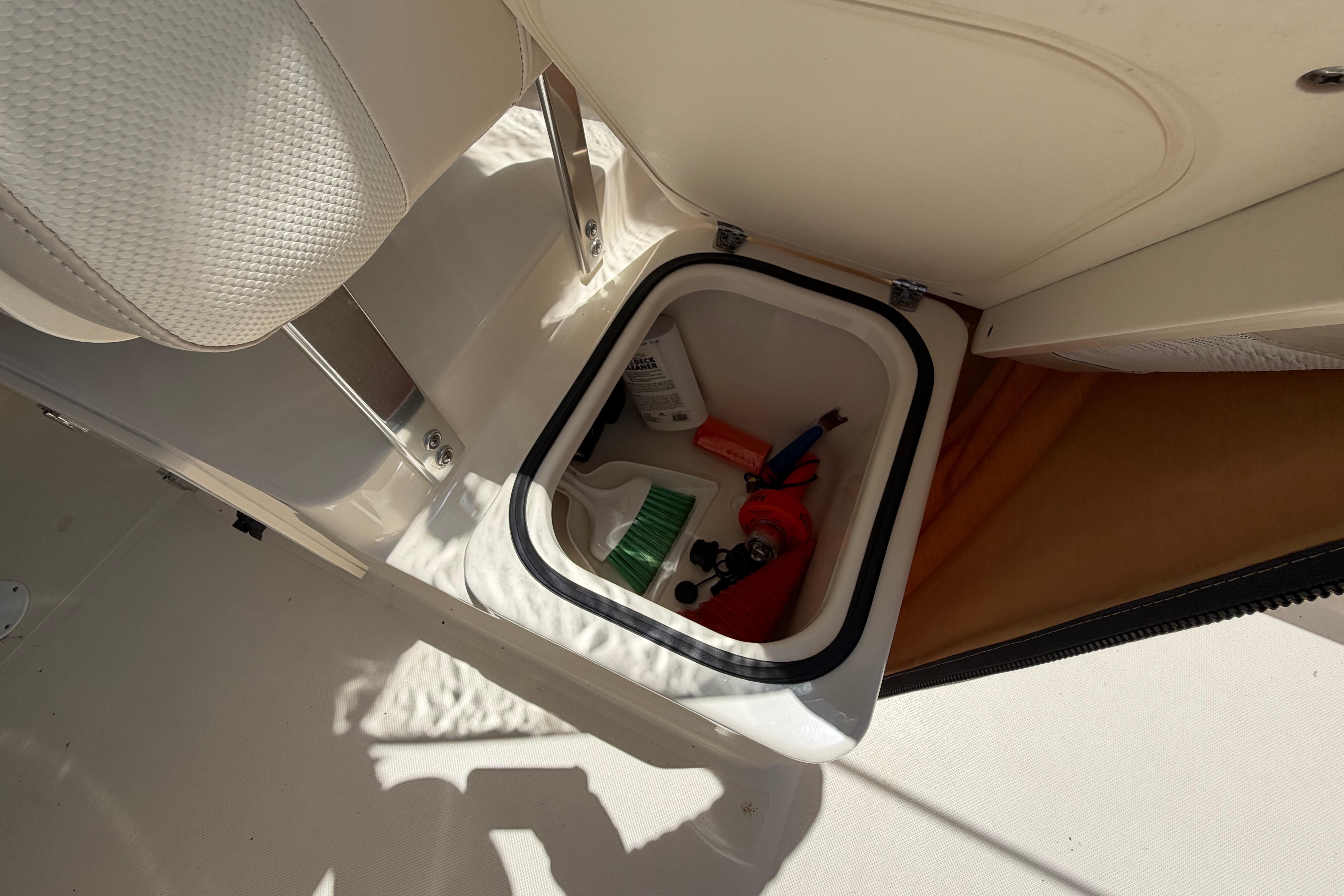 Storage compartment in a 2010 Pursuit OS 255 Offshore boat, containing cleaning supplies.
