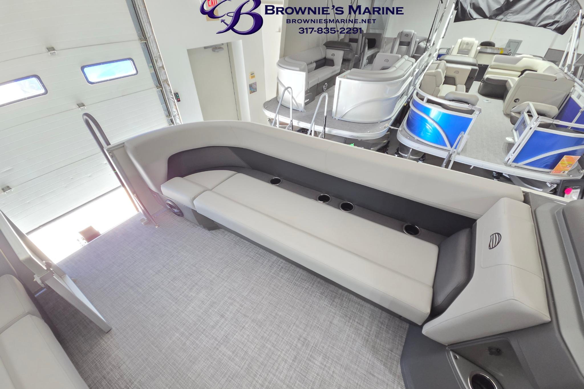 2026 Sun Tracker Party Barge 18 DLX interior with seating and cup holders in showroom.