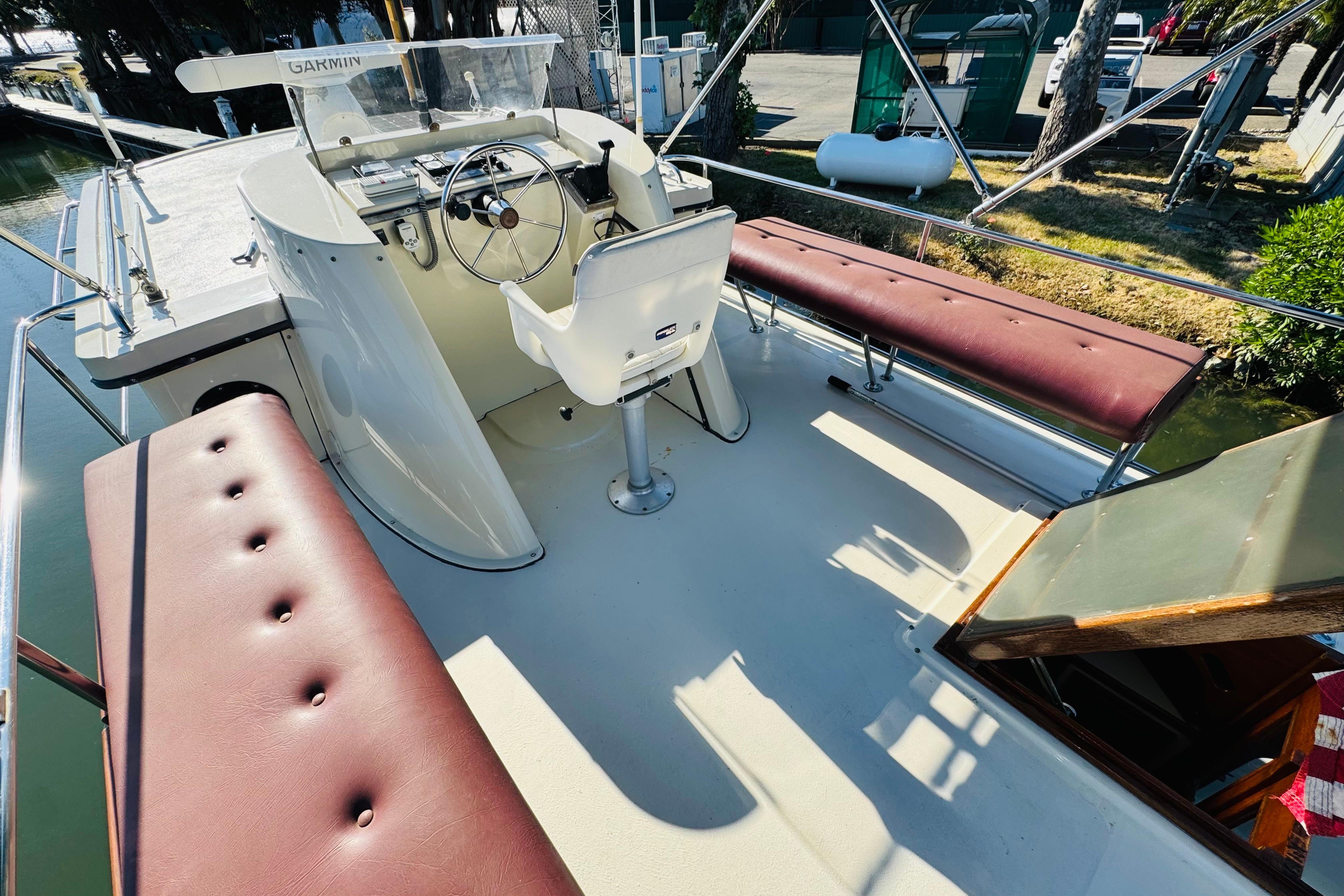 1996 Nordic Tug 32 boat cockpit with steering wheel, seating, and Garmin navigation system.