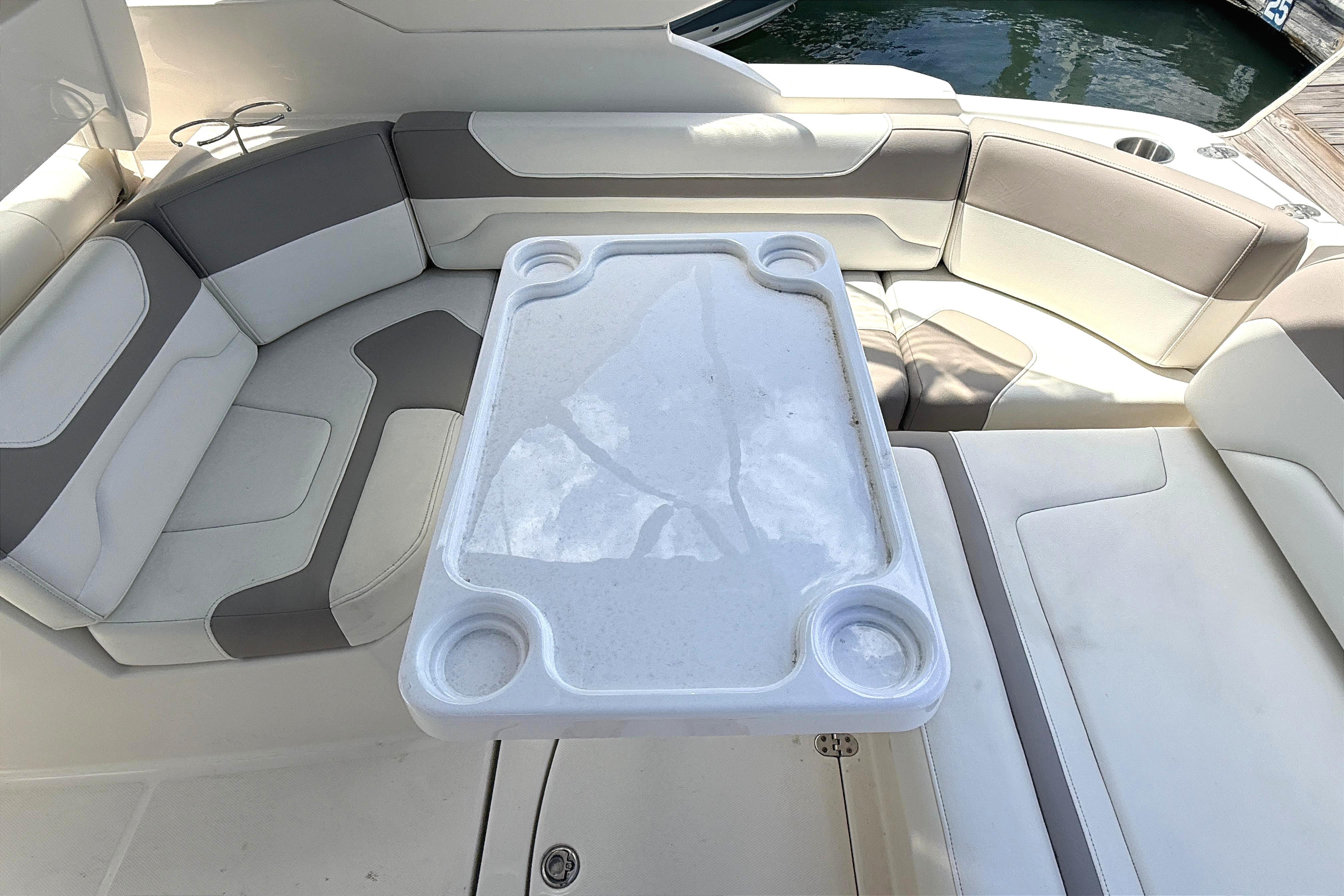 Interior seating area of a 2011 Monterey 320 Sport Yacht with a central table.