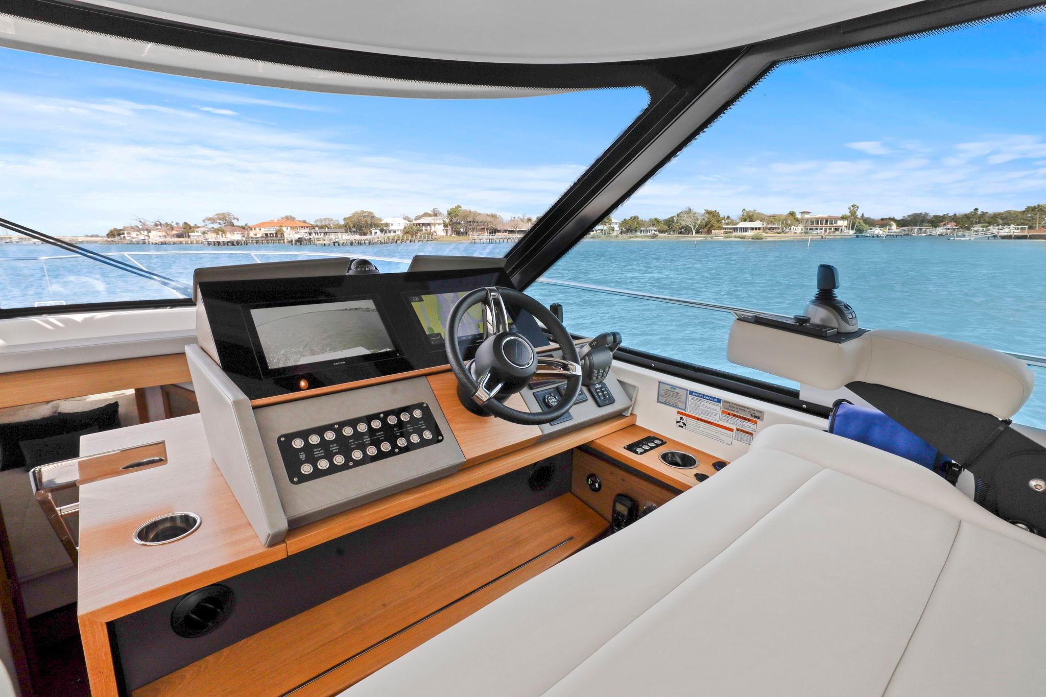 2023 Tiara Yachts C49 Coupe helm with modern controls and scenic water view.