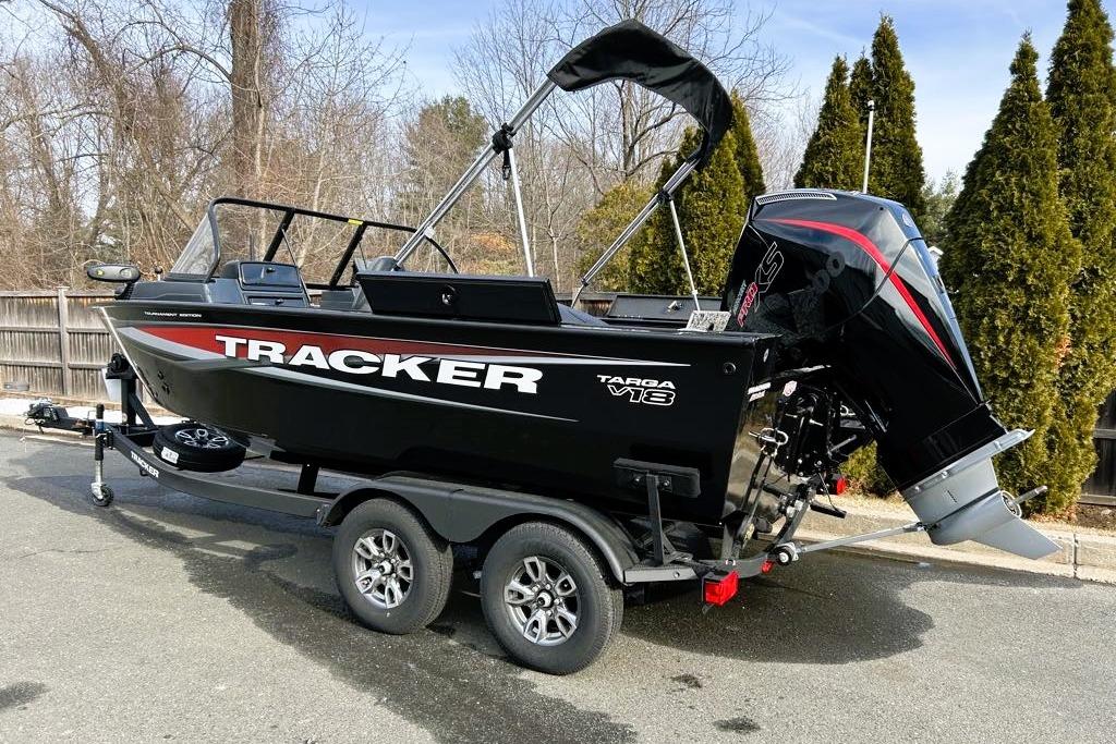 2026 Tracker Targa V-18 Combo boat on trailer, black with red accents, parked outdoors.
