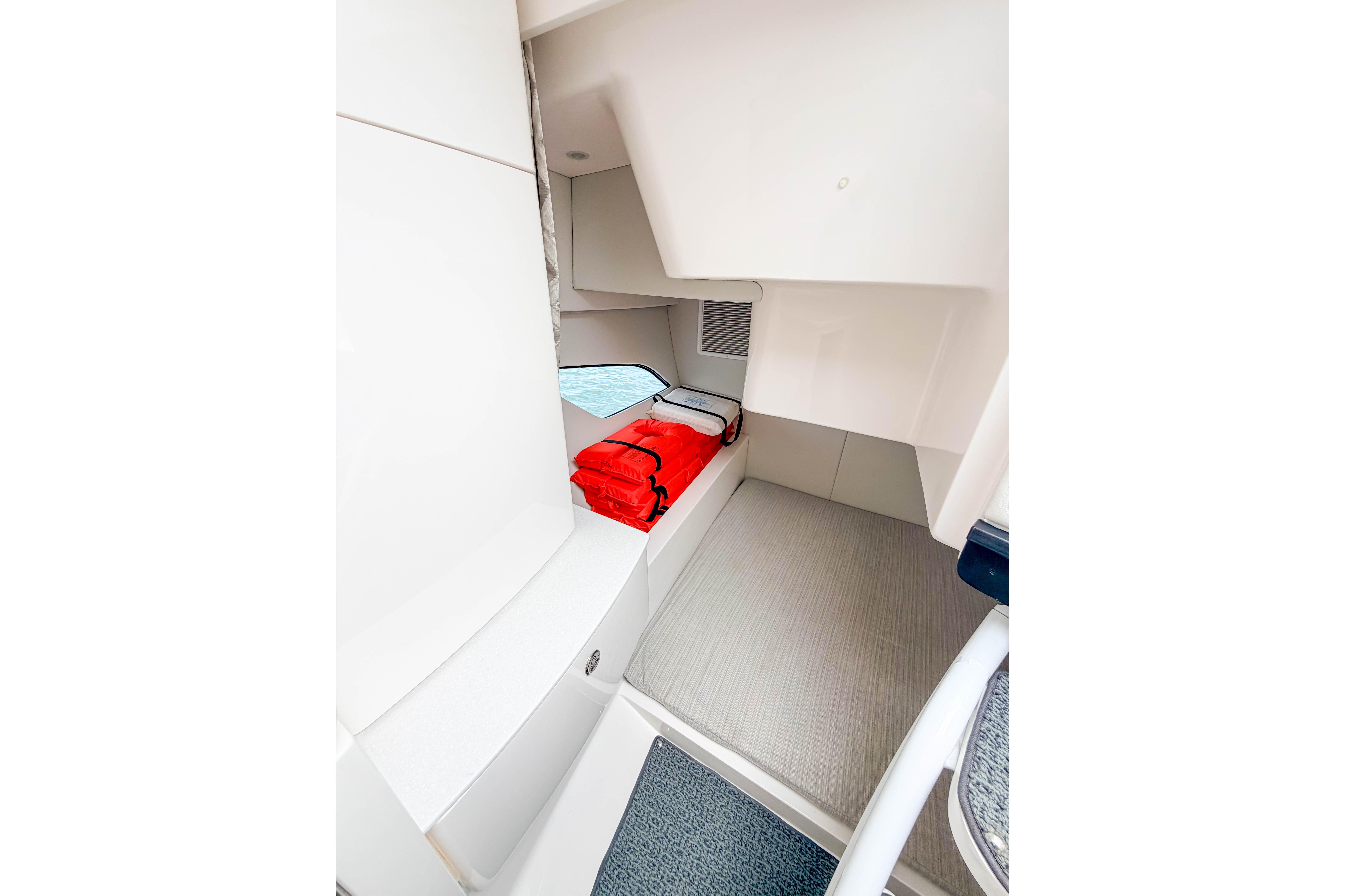 Interior cabin of 2021 Intrepid 409 Valor boat with red life jackets.