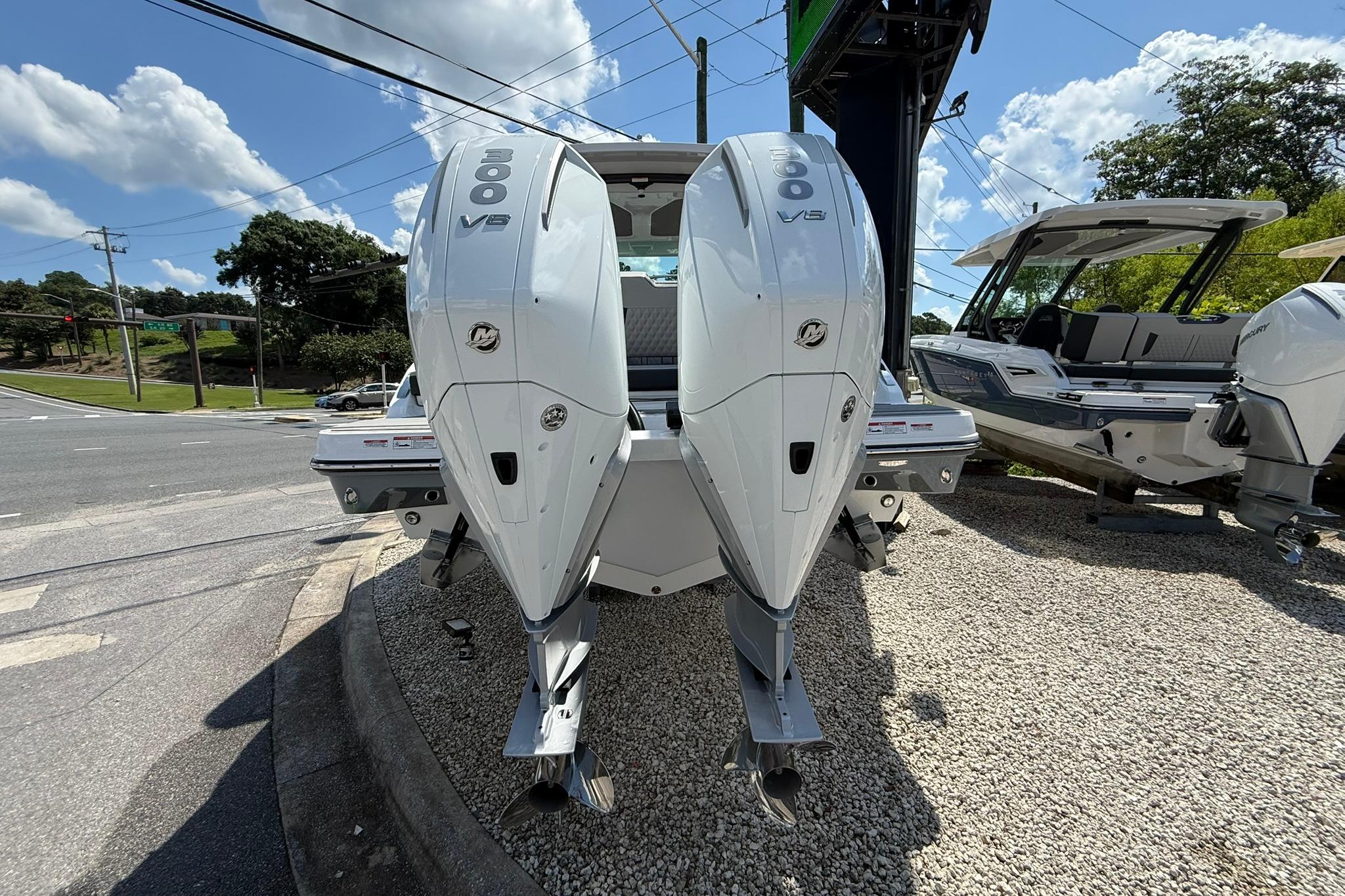 2027 Monterey Elite 30 OB boat with dual outboard engines on display.