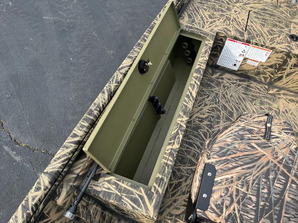 2024 Lowe Roughneck 1660 boat with open storage compartment and camouflage design.