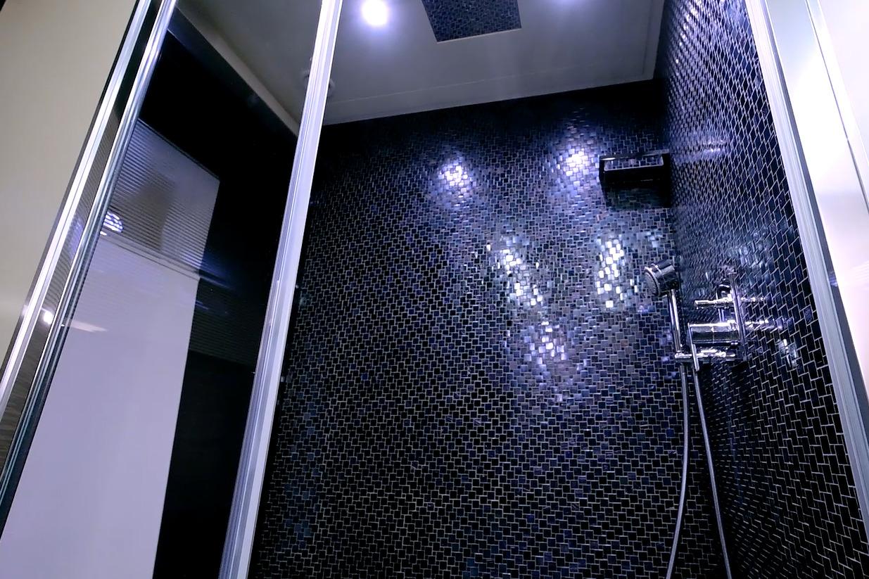 Luxurious shower with dark mosaic tiles in a 2015 Pershing 92 yacht.